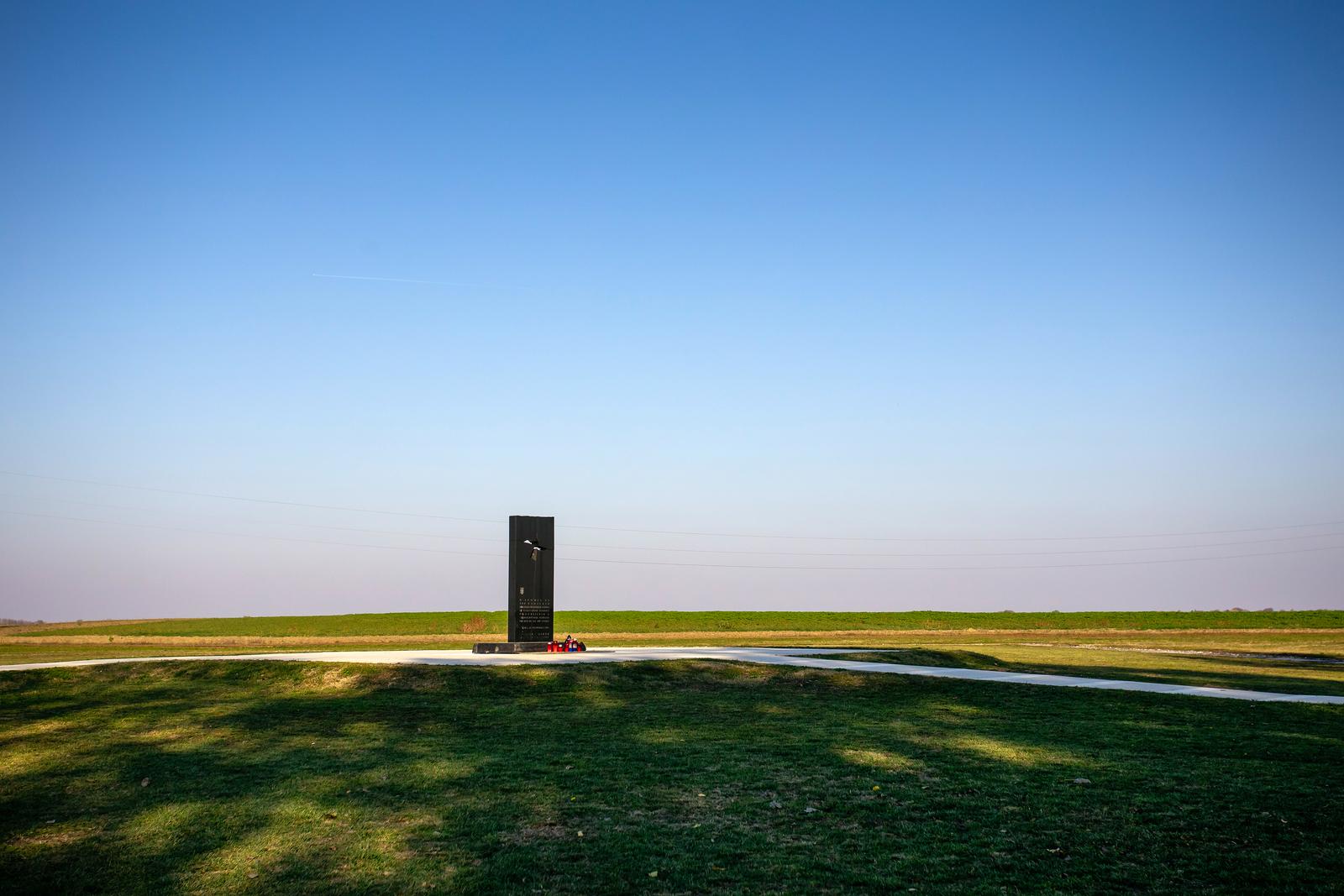 28.10.2021., Vukovar -  Pet kilometara jugoistocno od Vukovara nalazi se farma Ovcara koja je u suvremenoj hrvatskoj povijesti ostala zapamcena kao mjesto najveceg zlocina u Domovinskom ratu.
Hangar koji je u mirnodopsko vrijeme sluzio kao skladiste poljoprivredne mehanizacije od rujna 1991. godine pretvoren je u logor za nesrpsko stanovnistvo grada i okolice. U hangaru je 20. studenoga dovezeno vise od 260 hrvatskih branitelja i civila iz vukovarske bolnice. Po dolasku su im oduzete dragocjenosti i osobni predmeti te su krenula premlacivanja i torture. Prezivjeli su u vecernjim i nocnim satima istoga dana vozeni na lokaciji udaljenu oko jedan kilometar od hangara gdje ih je usred oranice cekala iskopana jama. Njih 200 smaknuto je hicima i zakopano bez ikakvog obiljezja. Danas se na mjestu hangara nalazi Spomen dom Ovcara koji cuva sjecanje na ranjenike i civile odvedene iz vukovarske bolnice, zatvorene i mucene u bivsem hangaru, a potom pogubljene i zakopane. Pokolj na Ovcari, odnosno pokolj u Vukovaru, bio je ratni zlocin koji su pocinili pripadnici JNA i srpskih paravojnih postrojba u noci s 20. na 21. studenoga 1991. godine tijekom srpske okupacije Vukovara. Tada je ubijeno izmedju 255 i 264 civila i vojnika, uglavnom Hrvata.To je bio najveci pojedinacni pokolj Domovinskog rata.  Medju ubijenima su bili francuski ratni dragovoljac Jean-Michel Nicolier i hrvatski novinar Sinisa Glavasevic. 
 Photo: Emica Elvedji/PIXSELL