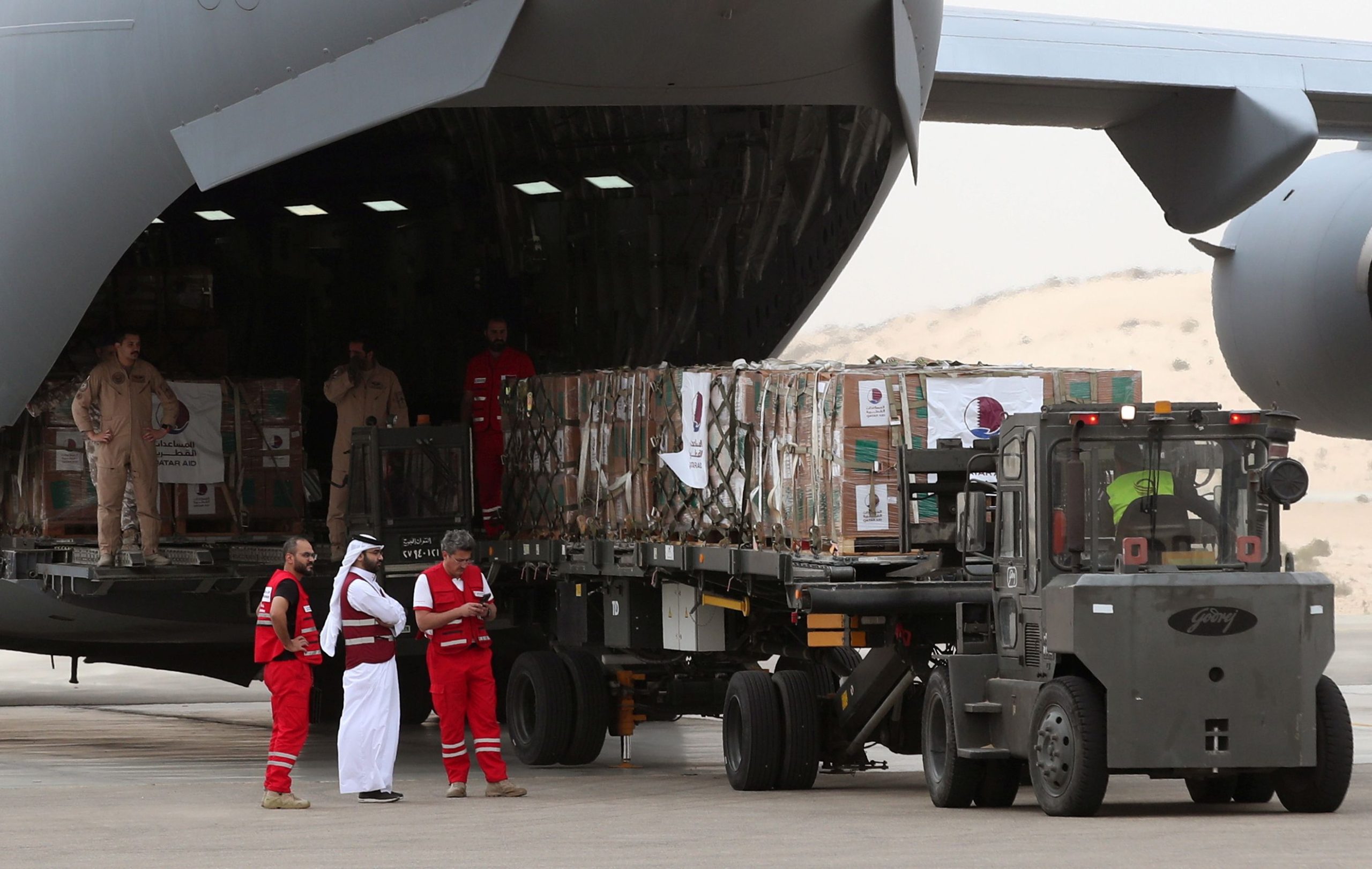 epa10984221 Volunteers from Qatari and Egypt’s Red Crescent humanitarian organizations unload aid destined for the Palestinians of the Gaza Strip at Egypt's Arish airport in the north Sinai, Egypt, 19 November 2023. According the UNRWA on 18 November,  "following long weeks of delay, Israeli Authorities approved only half of the daily minimum requirements of fuel for humanitarian operations in Gaza.", adding that it was far from enough to cover the needs of the displaced people and that "the last few days have seen a drastic reduction in these services including water availability and sewage clearance with serious consequences on people in need."  EPA/KHALED ELFIQI