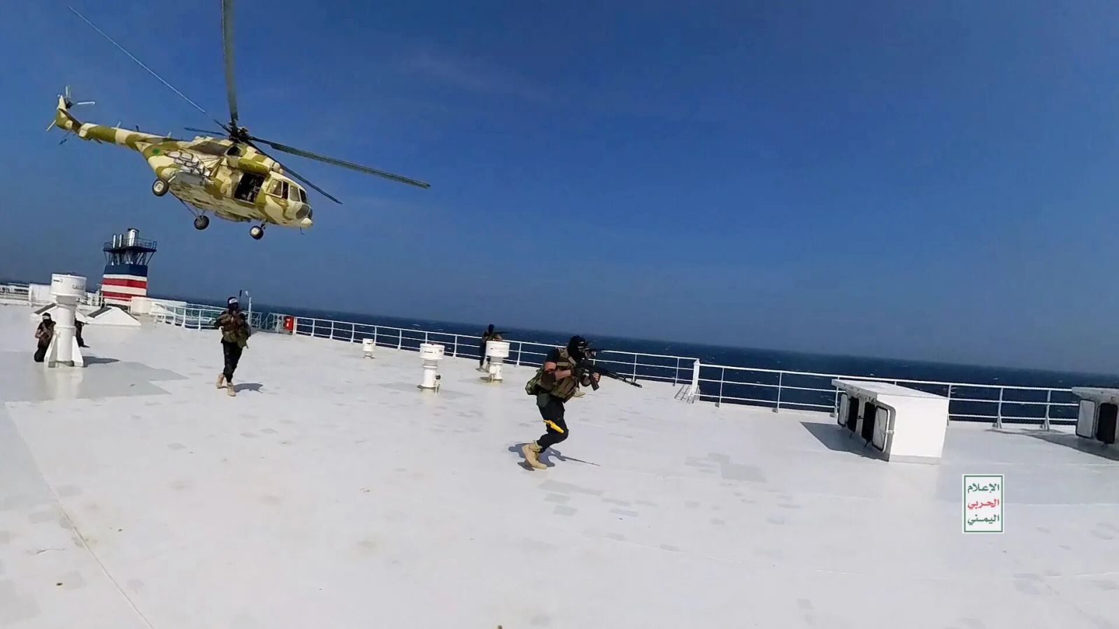 epa10986447 A handout photo made available by the Houthis media center shows a Houthis-operated helicopter flying as Houthi fighters run on the deck of the cargo ship Galaxy Leader seizing it in the Red Sea off the coast of Hodeidah, Yemen, 19 November 2023 (issued 20 November 2023). Yemen's Houthis have seized the cargo ship Galaxy Leader transiting the Red Sea, after threatening to target all ships owned or operated by Israeli companies or flying the Israeli flag amid the ongoing conflict between Israel and Hamas, according to a statement by the Houthis' military spokesman Yahya Sarea. Thousands of Israelis and Palestinians have died since the militant group Hamas launched an unprecedented attack on Israel from the Gaza Strip on 07 October, and the Israeli strikes on the Palestinian enclave which followed it.  EPA/HOUTHIS MEDIA CENTER / HANDOUT  HANDOUT EDITORIAL USE ONLY/NO SALES HANDOUT EDITORIAL USE ONLY/NO SALES