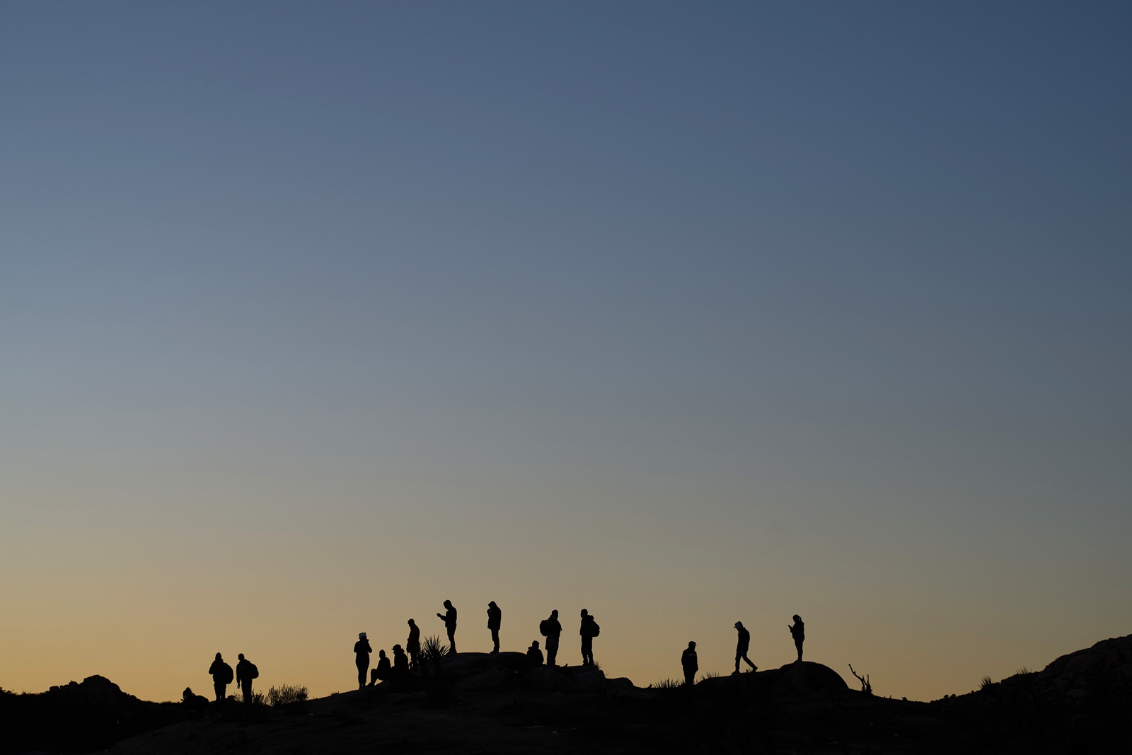 epaselect epa11000533 Migrants wait to be processed by US Border Patrol in Jacumba, California, USA, 28 November 2023. In recent weeks the tiny community of Jacumba, population 600, has been inundated with thousands of migrants taking temporary shelter outside in the desert due to US Border Patrol shelters being at maximum capacity.  EPA/ALLISON DINNER
