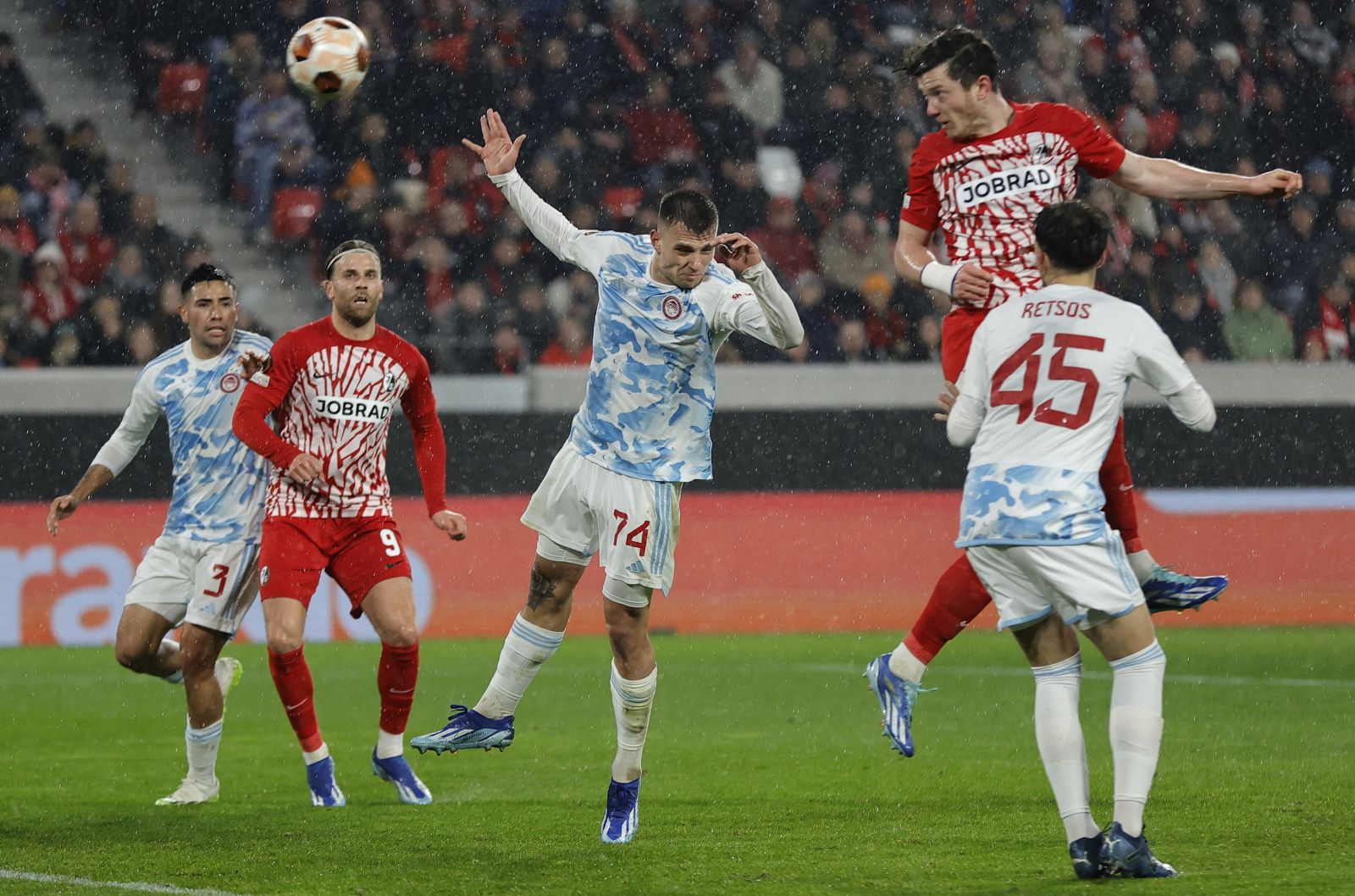 epa11003907 Freiburg's Michael Gregoritsch (top) scores his third goal in the UEFA Europa League Group A match between SC Freiburg and Olympiacos Piraeus in Freiburg, Germany, 30 November 2023.  EPA/RONALD WITTEK
