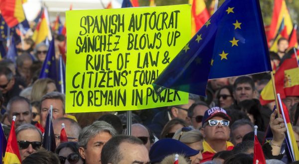 epa11008749 A demonstrator holds a banner during a rally called by the Spanish conservative People's Party in defense of the Spanish Constitution and to protest against the pacts reached by Spanish PM Pedro Sanchez with Catalan pro-independent parties, in Madrid, Spain, 03 December 2023. Sanchez was invested in a second term after PSOE party reached a deal with Catalan pro-independence party Junts per Catalunya (JxCat), led by former Catalan president Carles Puigdemont, by which Catalan separatists involved in the so-called independence 'process' in 2017 would be amnestied in exchange of the key support of seven JxCat MPs, among other concessions.  EPA/FERNANDO ALVARADO