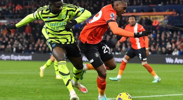 epa11012753 Jacob Brown (R) of Luton in action against Bukayo Saka of Arsenal during the English Premier League match between Luton Town and Arsenal in Luton, Britain, 05 December 2023.  EPA/VINCE MIGNOTT EDITORIAL USE ONLY. No use with unauthorized audio, video, data, fixture lists, club/league logos, 'live' services or NFTs. Online in-match use limited to 120 images, no video emulation. No use in betting, games or single club/league/player publications.