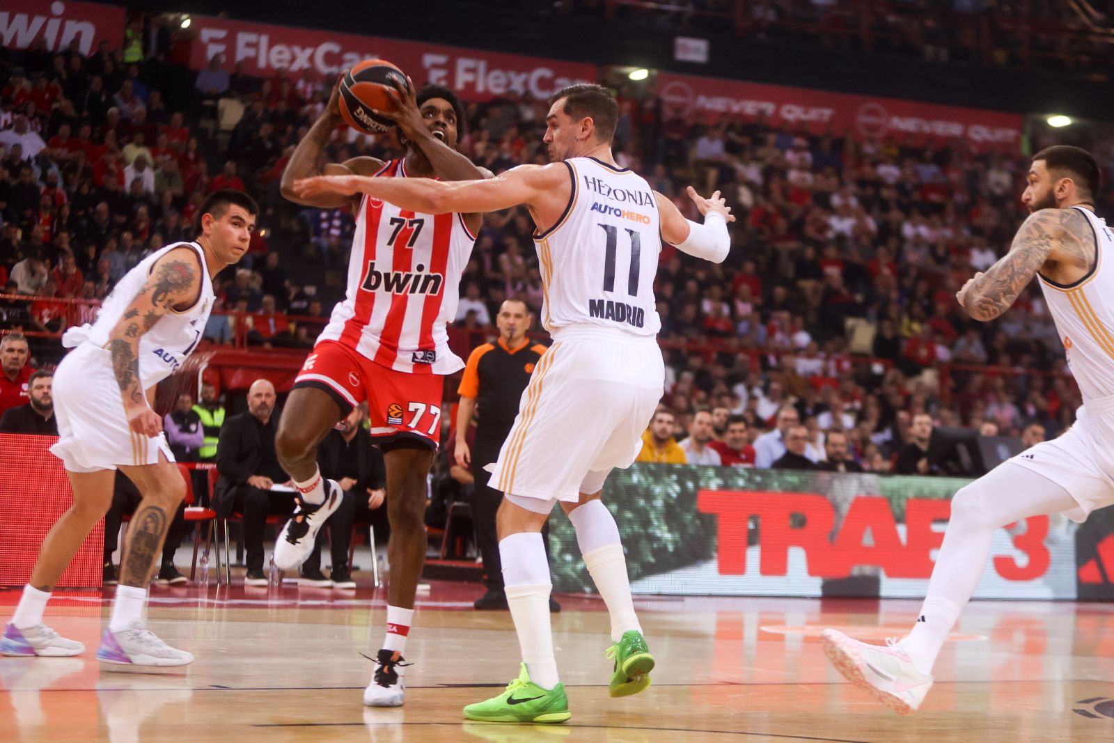 epa11012533 Olympiacos’ Saquielle McKissic (2-L) in action against Mario Hezonja (2-R) of Real Madrid during the Euroleague basketball match between Olympiacos Piraeus and Real Madrid, in Piraeus, Greece, 05 December 2023.  EPA/GEORGIA PANAGOPOULOU