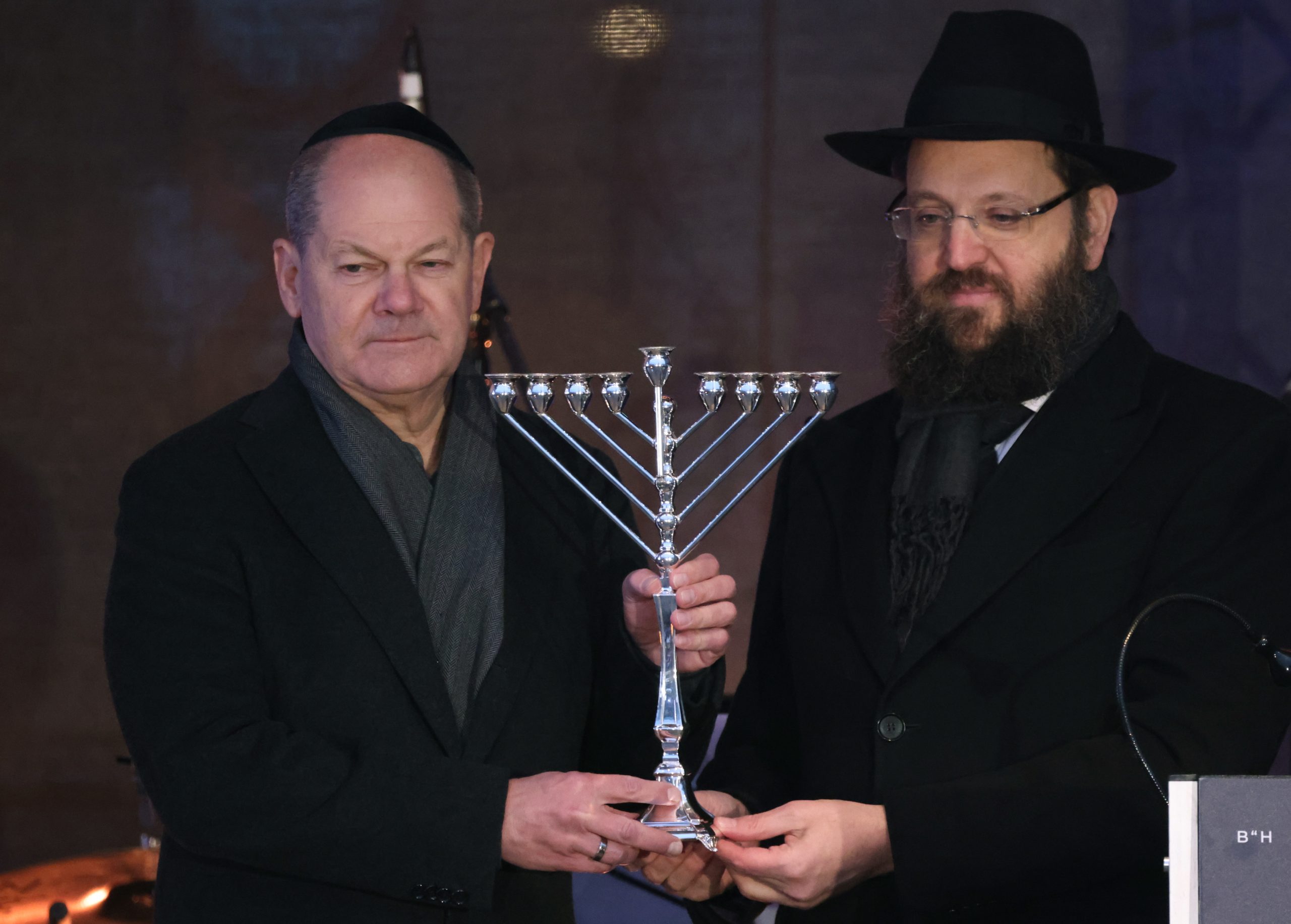 epa11015698 German Chancellor Olaf Scholz (L) receives a Menorah from Chairman of the Jewish Education Center Chabad Rabbi Yehuda Teichtal (R) during the lighting ceremony in front of a Hanukkah Menorah near the Brandenburg Gate in Berlin, Germany, 07 December 2023. Hanukkah, also known as the 'Festival of Lights', is one of the most important Jewish holidays and is celebrated by Jews worldwide.  EPA/CLEMENS BILAN