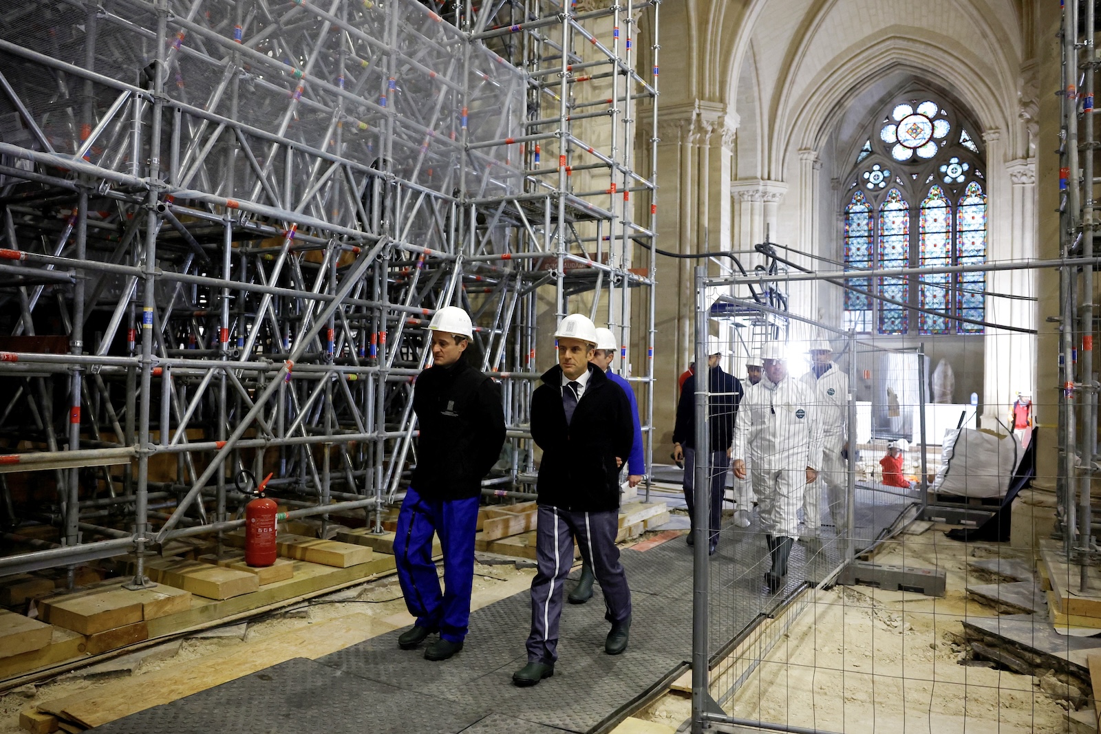 epa11017102 French President Emmanuel Macron (R front), wearing a working helmet, arrives to visit the nave of the Notre-Dame de Paris Cathedral, in Paris, France, 08 December 2023. French President Emmanuel Macron is visiting Notre Dame Cathedral on 08 December, to mark the one-year countdown to its reopening in 2024 following extensive restoration after the fire four years ago. Macron's visit, continuing his annual tradition since the blaze on 15 April 2019, is aimed to highlight the progress in the works, including the near completion of the cathedral spire.  EPA/SARAH MEYSSONNIER / POOL  MAXPPP OUT
