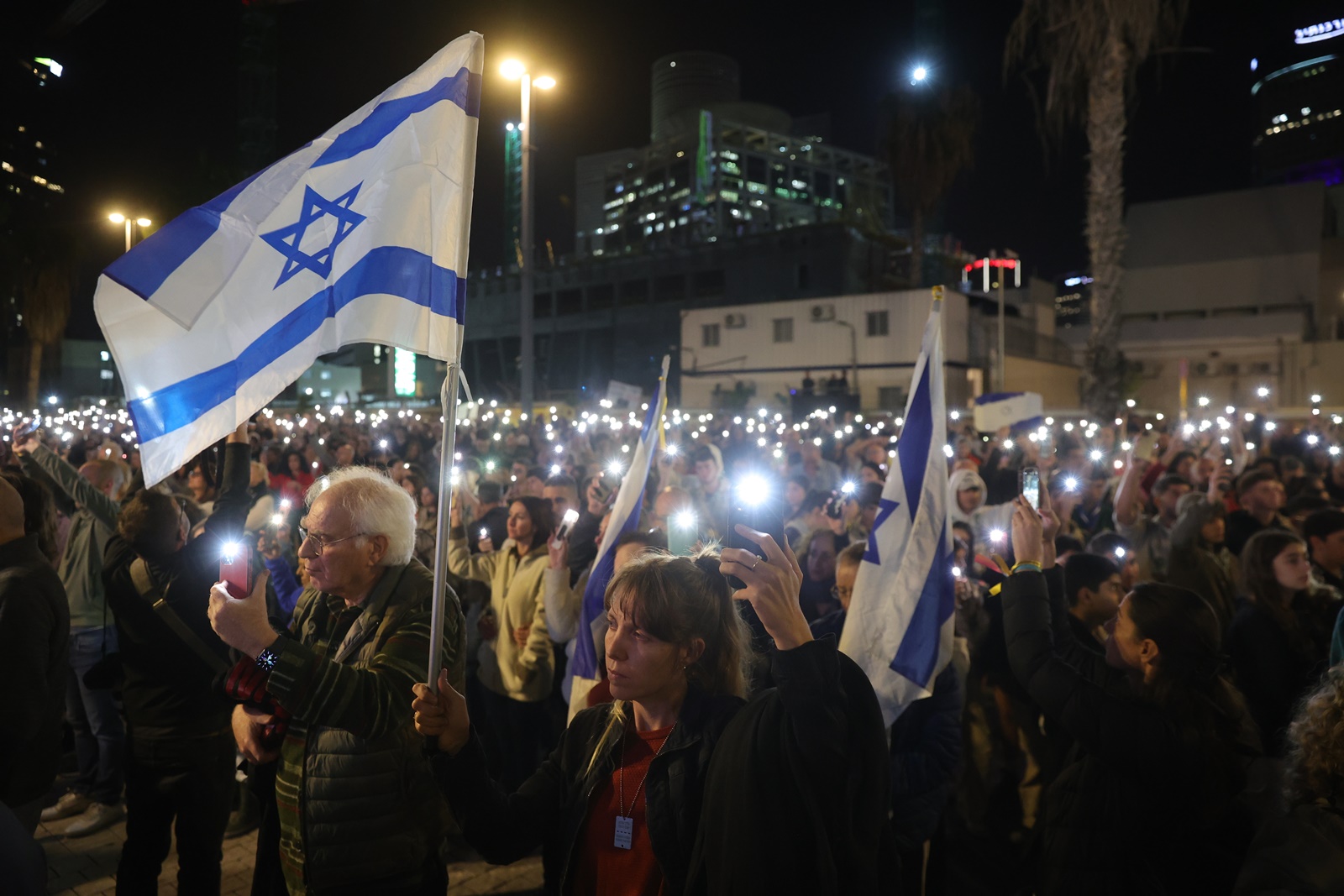 epa11019892 Family members and supporters of Israeli hostages held by Hamas in Gaza, hold up their phone lights calling for their release during a protest outside the Kirya military base in Tel Aviv, Israel , 09 December 2023. According to the Israeli army 137 Israelis are still held hostage in Gaza.  EPA/ABIR SULTAN