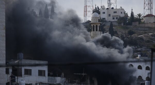 epa11026838 Smoke rises over residential buildings as the Israel Defence Force conduct a raid for the second day at a refugee camp near the West Bank city of Jenin, 13 December 2023. According to the Palestinian Health ministry, eight Palestinians were killed in Jenin during an Israeli military raid on 12 December. Thousands of Israelis and Palestinians have died since the militant group Hamas launched an unprecedented attack on Israel from the Gaza Strip on 07 October, and the Israeli operations in Gaza and the West Bank which followed it.  EPA/ALAA BADARNEH