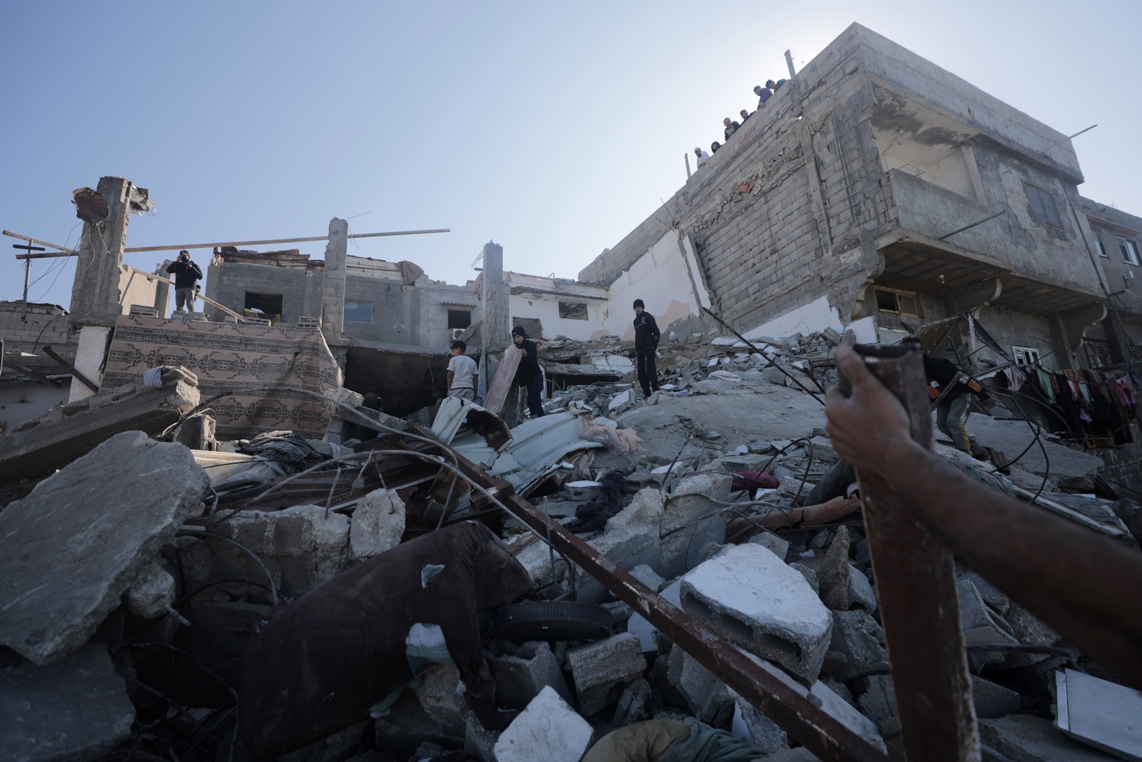 epa11037373 Palestinians inspect a destroyed house following an Israeli air strike in the east of Deir al Balah town, Gaza Strip, 19 December 2023. More than 60 members of two families were killed after an Israeli airstrike, the Palestinian Civil Defense said. Israeli forces resumed military strikes on Gaza after a week-long truce expired on 01 December. More than 15,000 Palestinians and at least 1,200 Israelis have been killed, according to the Gaza Government media office and the Israel Defense Forces (IDF), since Hamas militants launched an attack against Israel from the Gaza Strip on 07 October, and the Israeli operations in Gaza and the West Bank which followed it.  EPA/MOHAMMED SABER