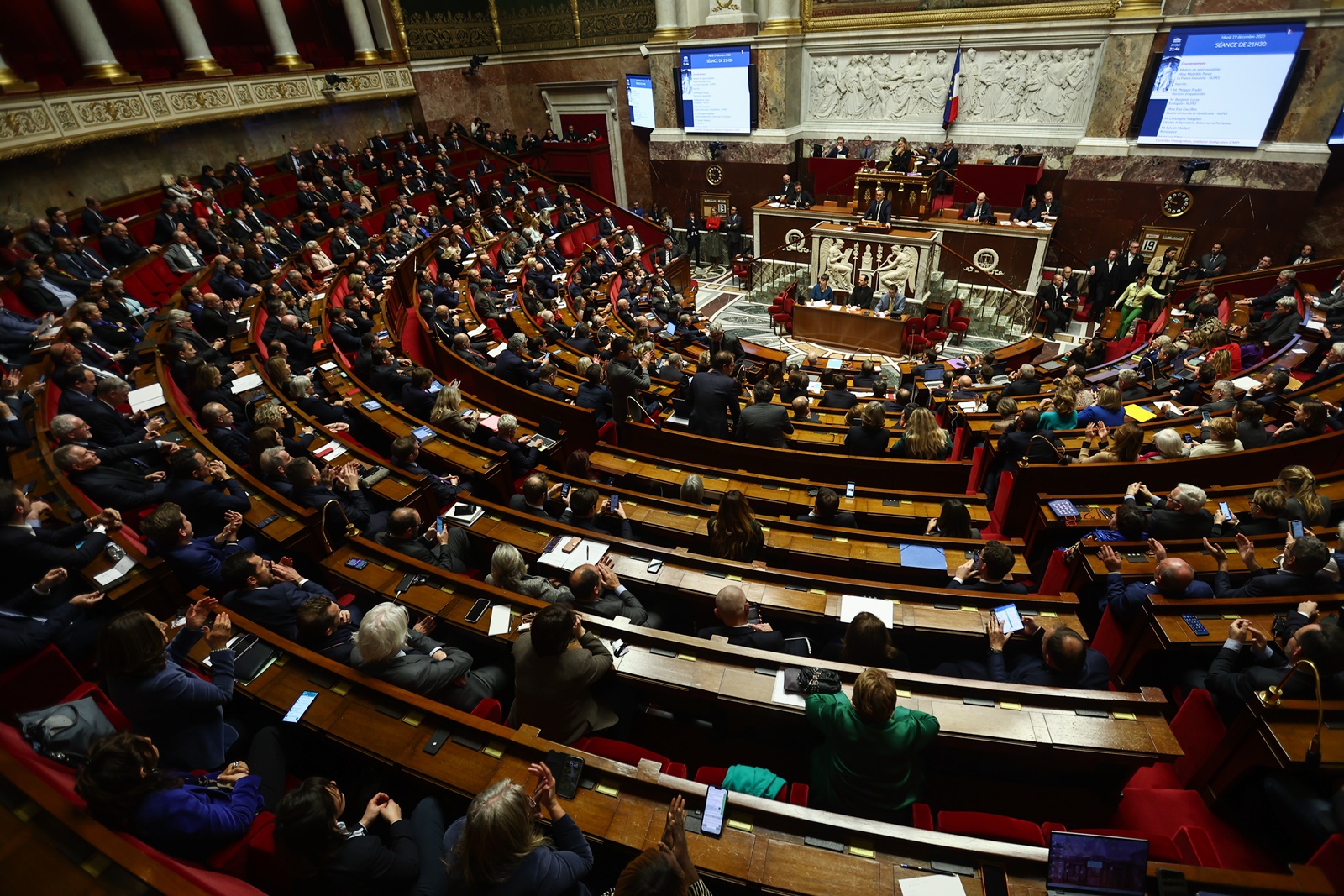 epa11037826 French Interior Minister Gerald Darmanin (C-rear) speaks during a debate on the new immigration bill at the National Assembly in Paris, France, 19 December 2023. A compromise on this very bill was found earlier on Tuesday in a joint commission of members of Parliament and Senators after it was rejected by Parliament last week. The far right party Rassemblement National decided to vote in favor of the text that hardens France's immigration policy.  EPA/Mohammed Badra