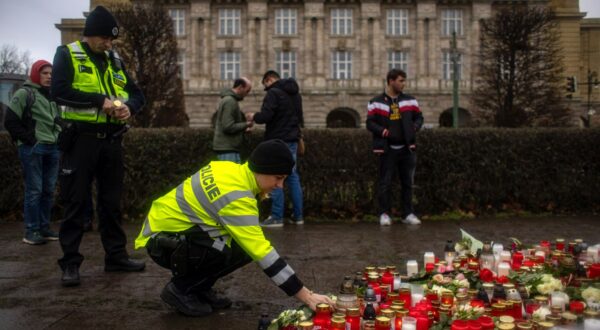 epa11040903 A police officer pays respects outside the Faculty of Philosophy building at Charles University following a mass shooting in central Prague, Czech Republic, 22 December 2023. According to the Czech Police President Martin Vondrasek, there are at least 14 people dead and 25 injured after the shooting at the Charles University on 21 December. According to Czech police the perpetrator was a 24 year-old Charles University student, who is also suspected of killing his father.  EPA/MARTIN DIVISEK