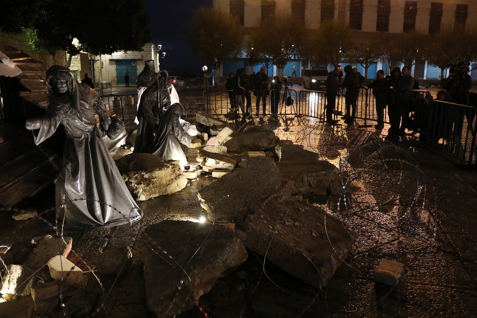 epa11042446 A Christmas installation scene surrounded by rubble and wires is displayed in Manger Square next to the Church of the Nativity in solidarity with the people of Gaza, in the West Bank town of Bethlehem, 23 December 2023. Church leaders in the historical Christian town of Bethlehem, traditionally revered as the birthplace of Jesus, have announced the cancellation of public Christmas celebrations this year in solidarity with the people of Gaza amid the ongoing Israel-Gaza conflict. Christmas activities will be limited to worship and prayer, without the usual Christmas lights and tree.  EPA/WISAM HASHLAMOUN