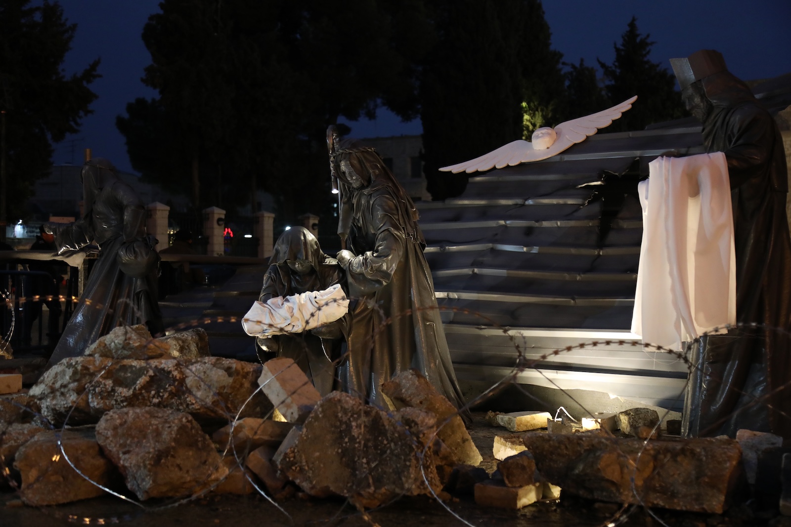 epa11042449 A Christmas installation scene surrounded by rubble and wires is displayed in Manger Square next to the Church of the Nativity in solidarity with the people of Gaza, in the West Bank town of Bethlehem, 23 December 2023. Church leaders in the historical Christian town of Bethlehem, traditionally revered as the birthplace of Jesus, have announced the cancellation of public Christmas celebrations this year in solidarity with the people of Gaza amid the ongoing Israel-Gaza conflict. Christmas activities will be limited to worship and prayer, without the usual Christmas lights and tree.  EPA/WISAM HASHLAMOUN