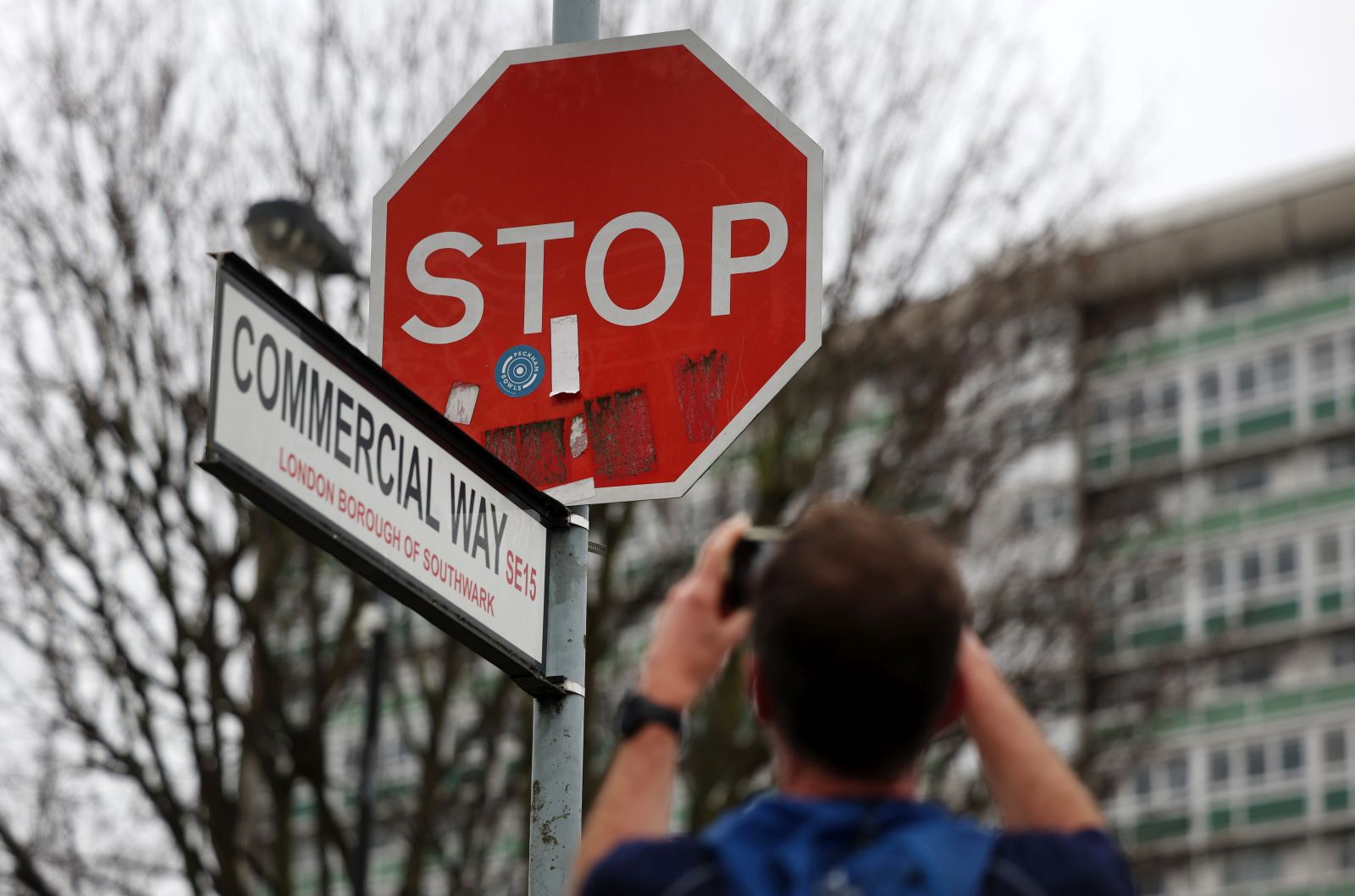 epa11042902 A local Londoner photographs a replaced Stop sign at Commercial Way in Peckham south London, Britain, 24 December 2023. A Stop sign has been replaced at the scene of a stolen Banksy Stop sign artwork depicting flying military drones. A man has been arrested after removing the Banksy artwork in south London on 22 December, the London police said.  EPA/ANDY RAIN