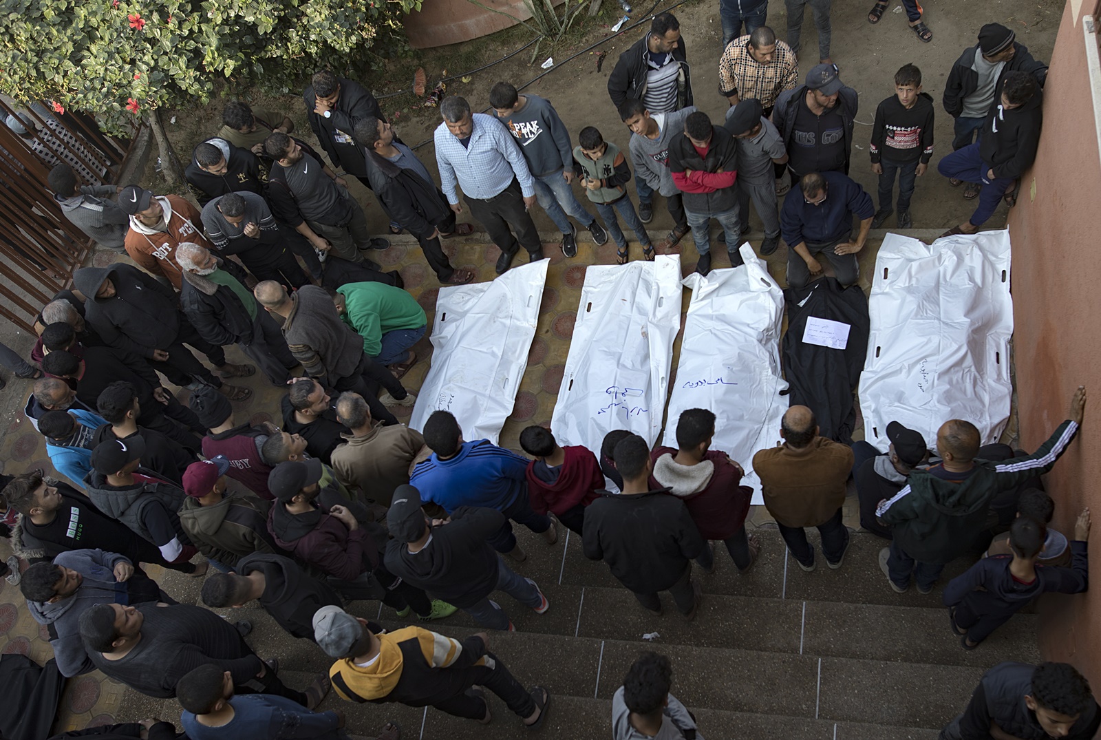 epa11045736 Relatives of killed Palestinians gather near their bodies at the Nasser Hospital in Khan Yunis, southern Gaza Strip, 27 December 2023, following Israeli air strikes on the Southern Gaza Strip. Israeli forces resumed military strikes on Gaza after the week-long truce ended on 01 December. More than 20,800 Palestinians and at least 1,300 Israelis have been killed, according to the Palestinian Health Ministry and the Israel Defense Forces (IDF), since Hamas militants launched an attack against Israel from the Gaza Strip on 07 October, and the Israeli operations in Gaza and the West Bank which followed it.  EPA/HAITHAM IMAD
