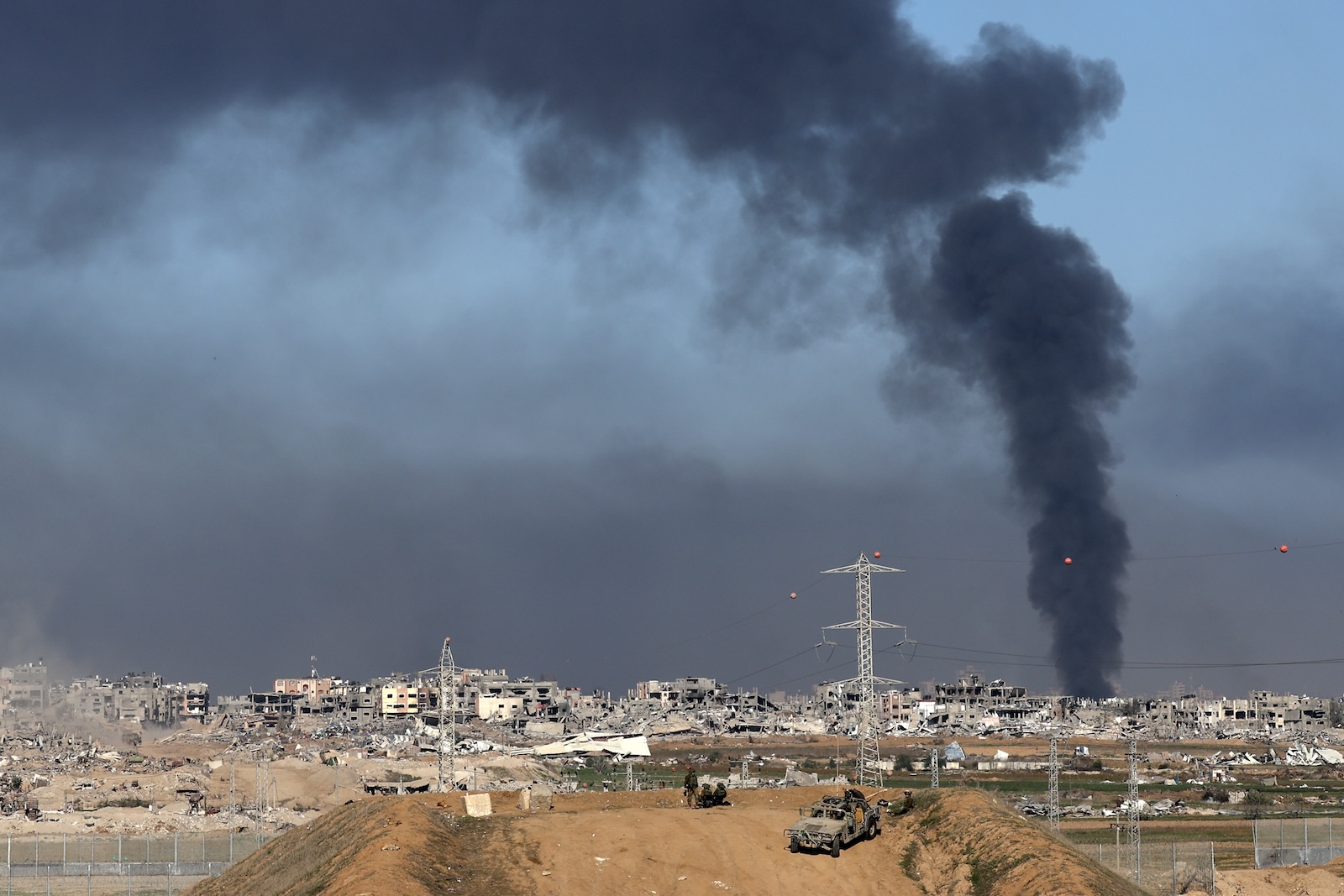 epa11047758 Israeli army soldiers stand guard at a position near the Israeli-Gaza border, as smoke rises above the Shujaiya neighborhood in the Gaza Strip, in southern Israel, 29 December 2023. More than 20,900 Palestinians and at least 1,300 Israelis have been killed, according to the Palestinian Health Ministry and the Israel Defense Forces (IDF), since Hamas militants launched an attack against Israel from the Gaza Strip on 07 October, and the Israeli operations in Gaza and the West Bank which followed it. The Israeli military stated that its ground, air, and naval troops are 'continuing to strike' targets in the Gaza Strip.  EPA/ATEF SAFADI