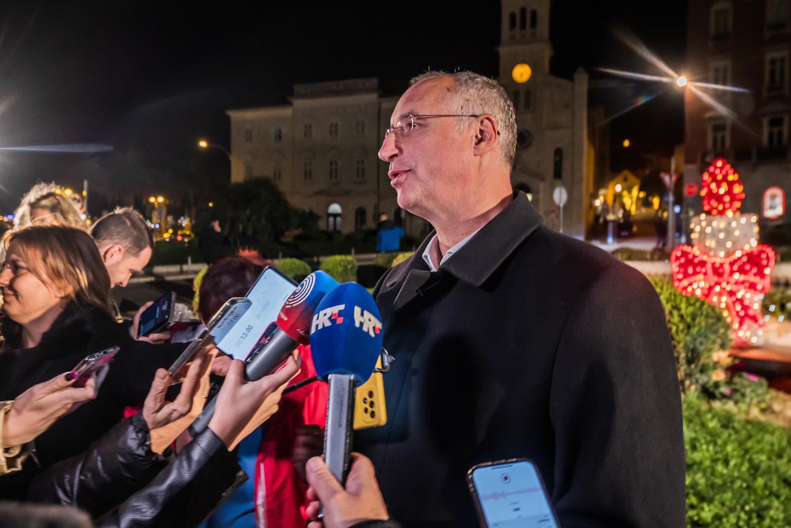 02.12.2023., Split - Gradonacelnik Ivica Puljak, direktorica splitske Turisticke zajednice Alijana Vuksic i fra Martin Jakovic, zupnik i gvardijan Samostana sv. Frane, zapalili su prvu svijecu na adventskom vijencu kraj fontane na Rivi, cime su sluzbeno otvorili Splitski Advent.
 Photo: Zvonimir Barisin/PIXSELL