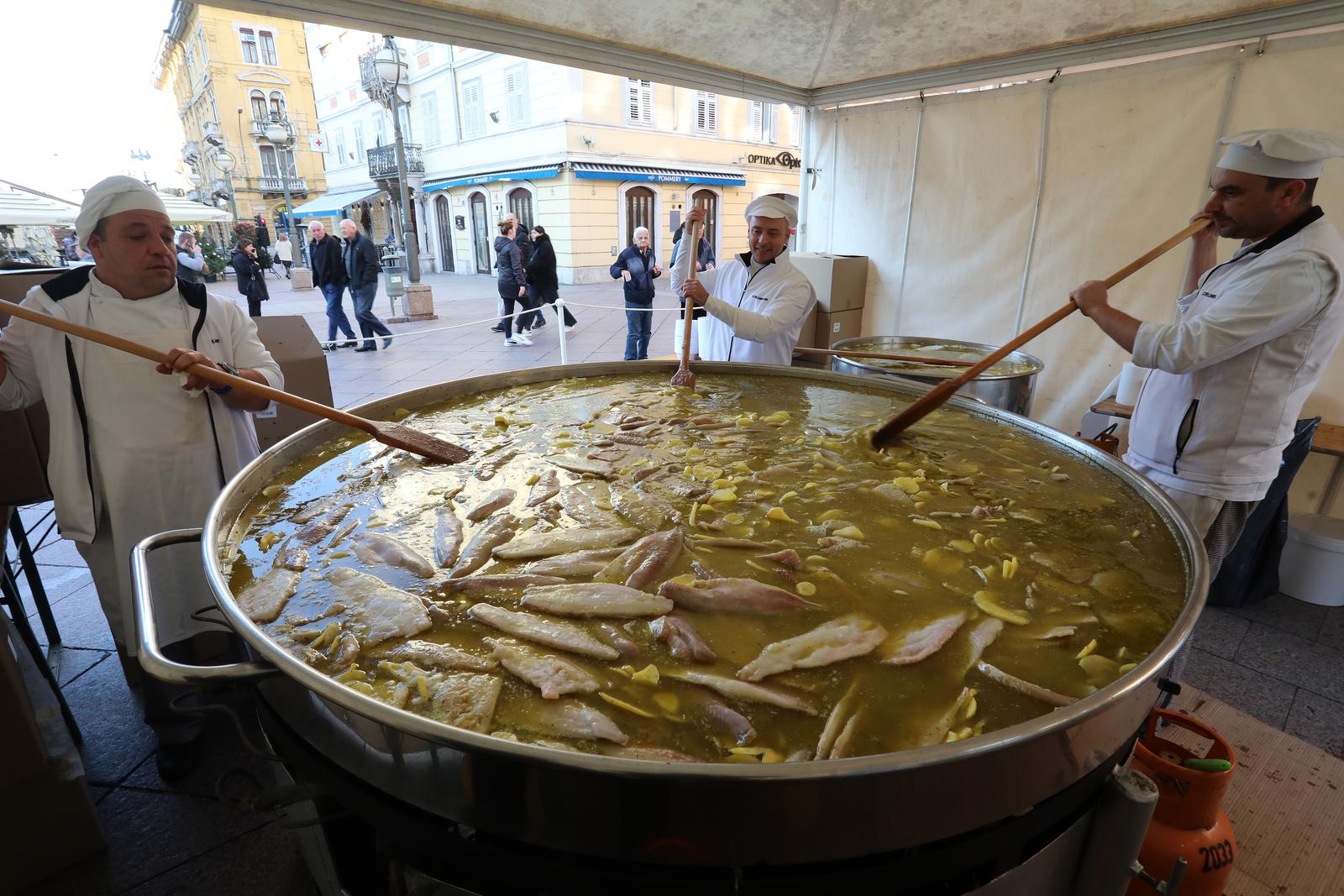 22.12.2023., Rijeka - Na Trgu 128 brigade HV i Korzu odrzava se tradicionalna Gastrofesta, zajednicka predblagdanska marenda za gradjane. Ove se godine pripremaju frigane sardele, bakalar na gulas, bakalar na bijelo i vrbnicka zlahtina. Biti ce podijeljeno 2000 porcija sardela, 2500 porcija bakalara na gulas, 3000 kanape sendvica bakalara na bijelo i 3000 casa zlahtine. Photo: Goran Kovacic/PIXSELL