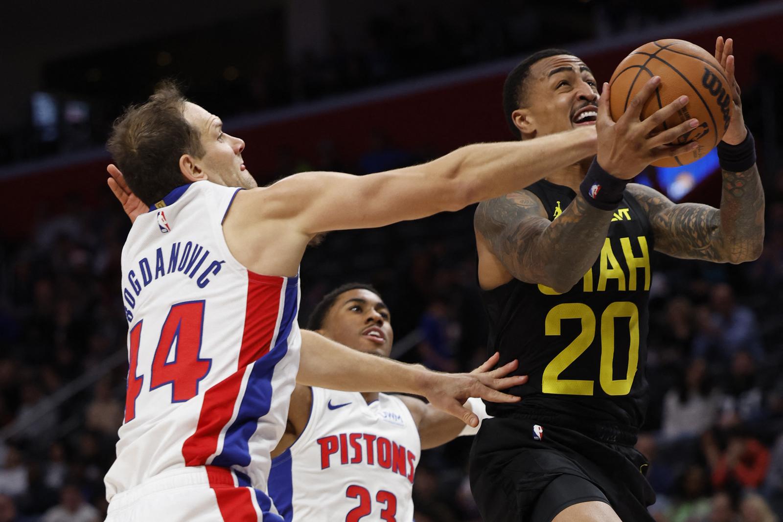 Dec 21, 2023; Detroit, Michigan, USA;  Utah Jazz forward John Collins (20) is fouled by Detroit Pistons forward Bojan Bogdanovic (44) in the second half at Little Caesars Arena. Mandatory Credit: Rick Osentoski-USA TODAY Sports Photo: Rick Osentoski/REUTERS