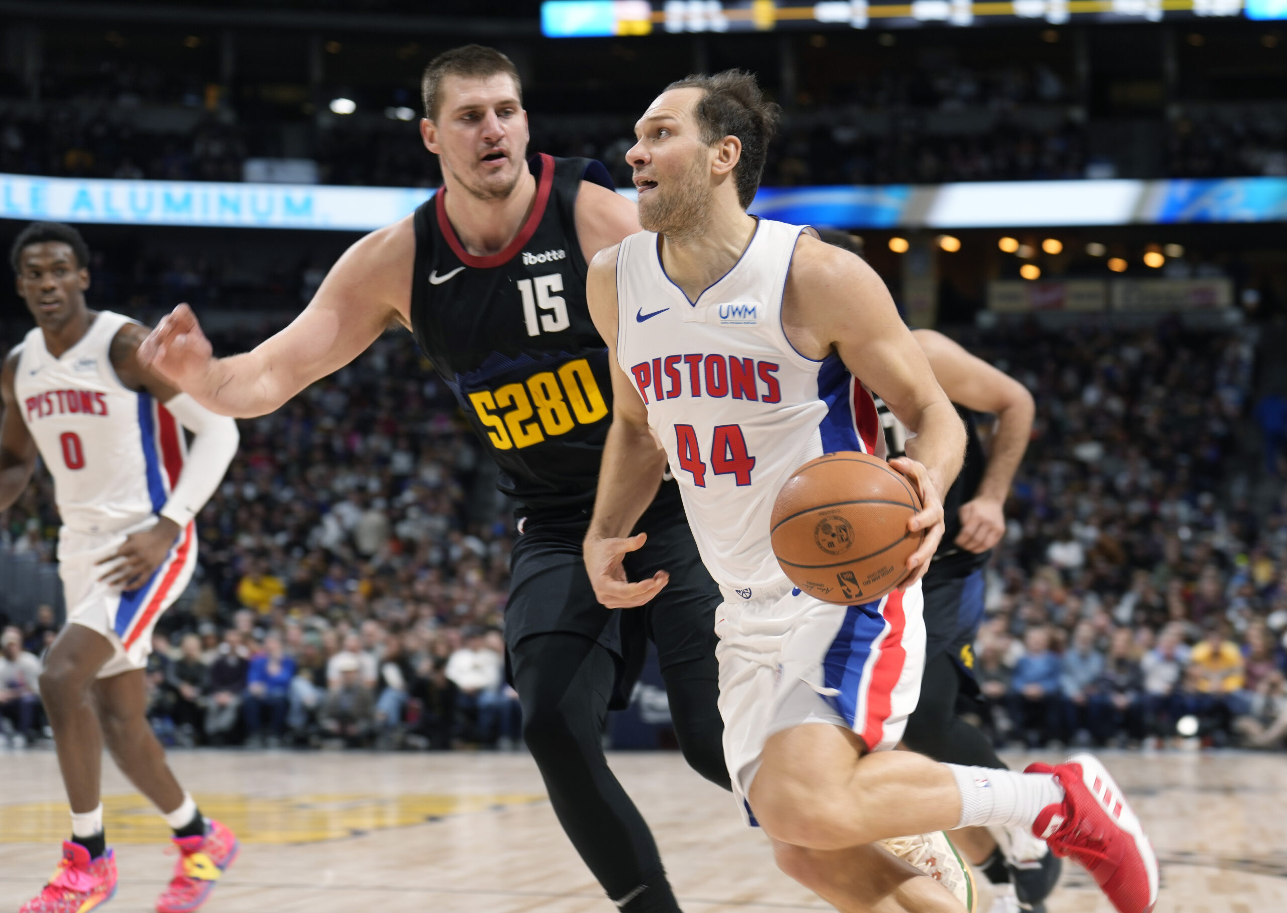 Detroit Pistons forward Bojan Bogdanovic (44) drives past Denver Nuggets center Nikola Jokic (15) in the second half of an NBA basketball game Sunday, Jan. 7, 2024, in Denver. (AP Photo/David Zalubowski)