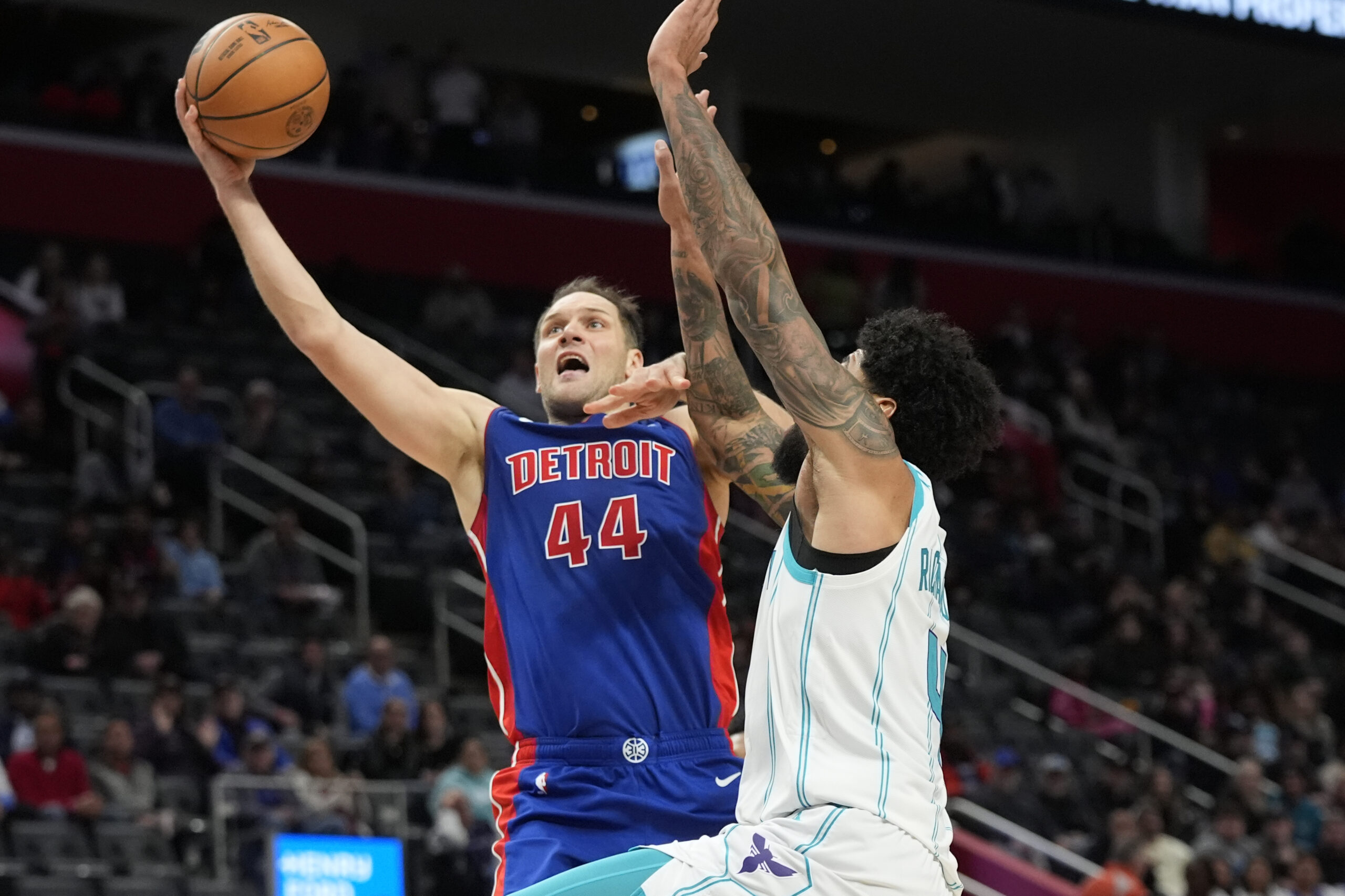 Detroit Pistons forward Bojan Bogdanovic (44) makes a layup as Charlotte Hornets center Nick Richards (4) defends during the second half of an NBA basketball game, Wednesday, Jan. 24, 2024, in Detroit. (AP Photo/Carlos Osorio)