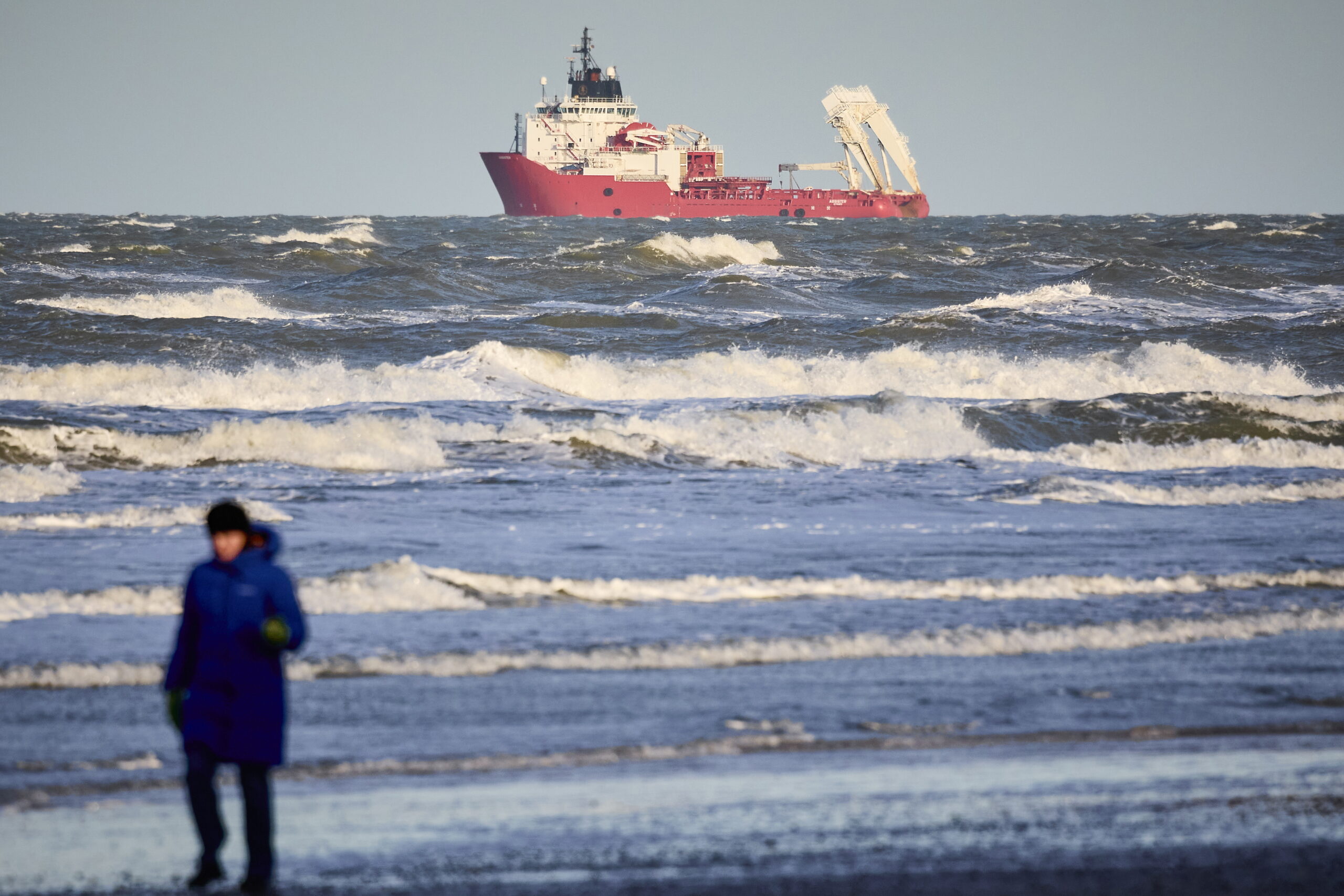 epa11044600 The salvage ship Assister sails along Blokhus Strand on the West Coast in North Jutland, Denmark, 26 December 2023. The salvage ship is hired by Maersk to locates and pick the containers after a Maersk ship dropped 46 containers off the coast between Bulbjerg and Svinkloev in the northwestern part of Jutland during storm Pia.  EPA/Claus Bjoern Larsen  DENMARK OUT