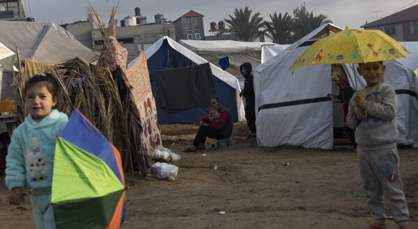 epa11053202 Displaced children hold umbrellas after a rainy night at a camp near Nasser Hospital in Khan Yunis, southern Gaza Strip, 02 January 2024. More than 21,800 Palestinians and at least 1,300 Israelis have been killed, according to the Palestinian Health Ministry and the Israel Defense Forces (IDF), since Hamas militants launched an attack against Israel from the Gaza Strip on 07 October 2023, and the Israeli operations in Gaza and the West Bank which followed it. Since 07 October, up to 1.9 million people, or more than 85 percent of the population, have been displaced throughout the Gaza Strip, some more than once, according to the United Nations Relief and Works Agency for Palestine Refugees in the Near East (UNRWA), which added that most civilians in Gaza are in 'desperate need of humanitarian assistance and protection'.  EPA/HAITHAM IMAD