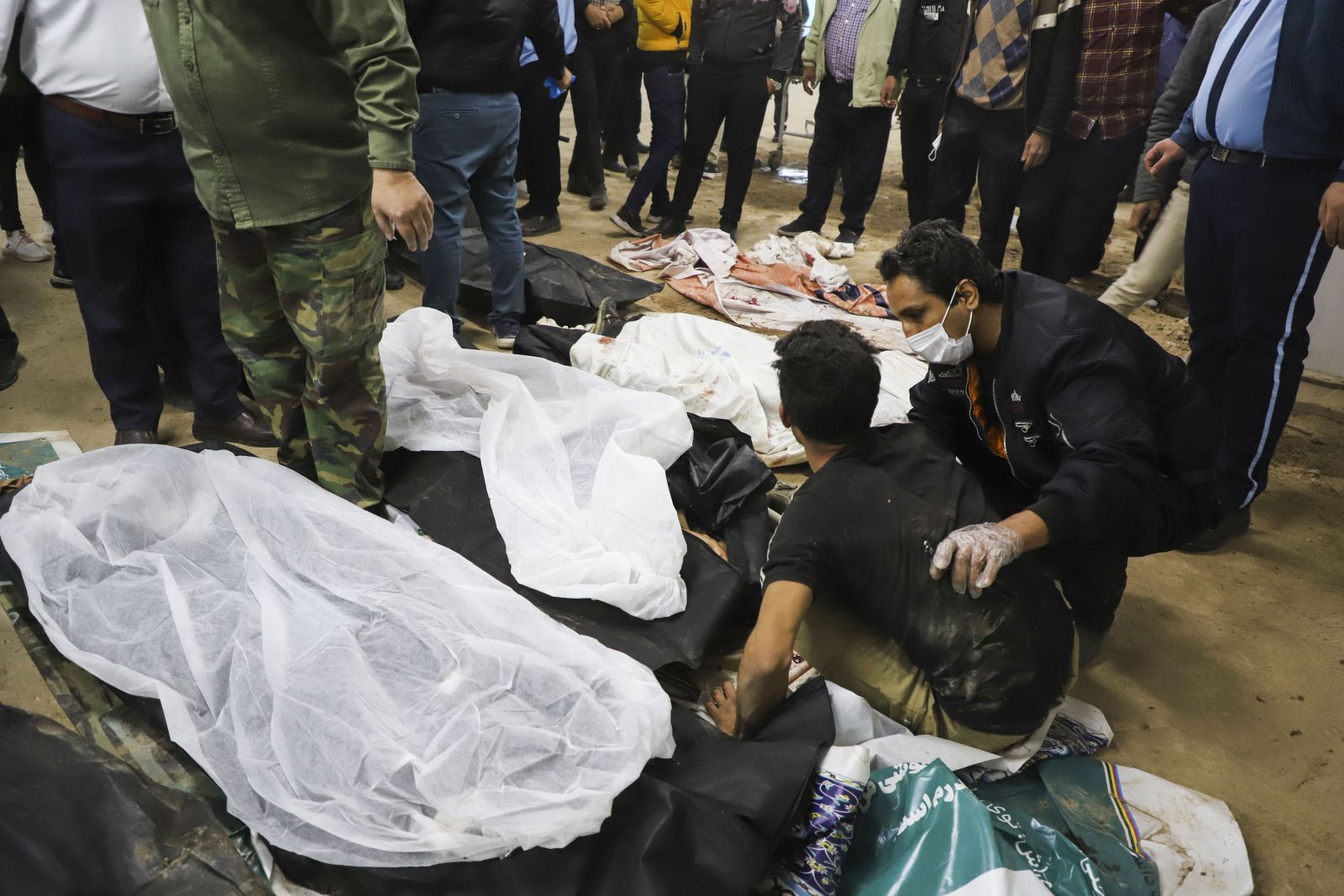 epa11055687 People mourn over bodies of victims after explosions at a commemoration ceremony next to the tomb of Iran's Revolutionary Guards chief of foreign operations Iranian General Qasem Soleimani in the Saheb al-Zaman mosque in the southern city of Kerman, Iran, 03 January 2024. On the fourth anniversary of the assassination of Iranian General Qasem Soleimani, two explosions have killed at least 100 people and another 171 people were wounded near the mausoleum dedicated to him, according to Iranian state television. As part of a ceremony to honor General Soleimani, who was killed in a drone strike in neighboring Iraq in 2020, hundreds of people were on their way towards the grave on 03 January.  EPA/SARE TAJALLI