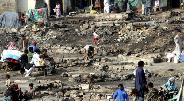 epa11058682 People are seen at a damaged area after a fire broke out in the slums beneath the Teen Hatti Bridge, engulfing more than 15 huts, in Karachi, Pakistan, 05 January 2024. While over 100 huts suffered damage, no loss of life has been reported, officials said. The fire is under control and the cooling process is underway as fire brigades and police were deployed to the area.  EPA/REHAN KHAN
