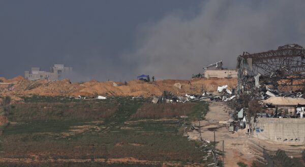 epa11067078 Israeli troops in position as smoke rises over Buraij refugee camp in the central Gaza Strip, as seen from an undisclosed location in Israel 10 January 2024. More than 22,800 Palestinians and at least 1,300 Israelis have been killed, according to the Palestinian Health Ministry and the Israel Defense Forces (IDF), since Hamas militants launched an attack against Israel from the Gaza Strip on 07 October, and the Israeli operations in Gaza and the West Bank which followed it.  EPA/ATEF SAFADI