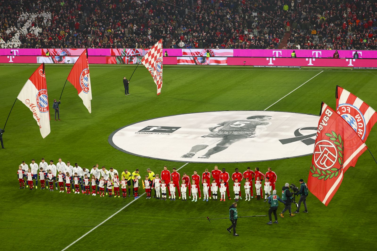 epa11072224 Players and spectators hold a minute of silence for former German soccer legend Franz Beckenbauer prior the German Bundesliga soccer match between FC Bayern Munich and Hoffenheim in Munich, Germany, 12 January 2024. Beckenbauer passed away on 07 January 2024 at the age of 78.  EPA/ANNA SZILAGYI CONDITIONS - ATTENTION: The DFL regulations prohibit any use of photographs as image sequences and/or quasi-video.