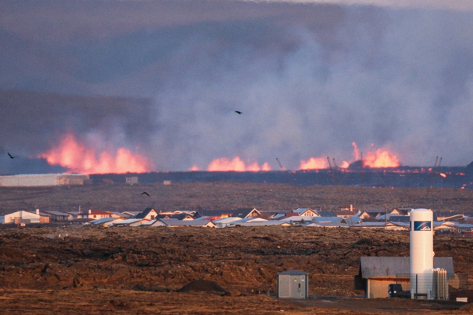 epa11077217 Lava explosions and rising smoke after a volcanic eruption near the town of Grindavik, in the Reykjanes peninsula, southwestern Iceland, 14 January 2024. A volcanic eruption began north of the town of Grindavik on the Reykjanes peninsula on 14 January, prompting authorities in Iceland to evacuate the small fishing town in the early morning as a precaution. The eruption is not expected to impact additional populated areas and does not present a 'threat to life', the Government of Iceland stated, adding that there are no disruptions to flights to and from Iceland. This is the second eruption in the area since December 2023, and the fifth since 2021.  EPA/ANTON BRINK