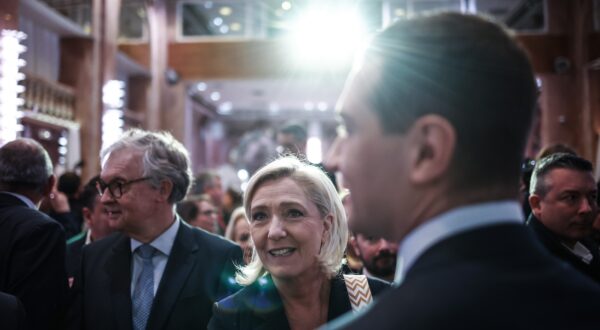 epa11079290 French member of Parliament for far-right Rassemblement National (RN) party Marine Le Pen (C) looks on after French far-right party Rassemblement National (RN) president Jordan Bardella (R) delivered his speech, during a conference to present his Best Wishes 2024 to the Press, at Salons Hoche in Paris, France, 15 January 2024.  EPA/YOAN VALAT
