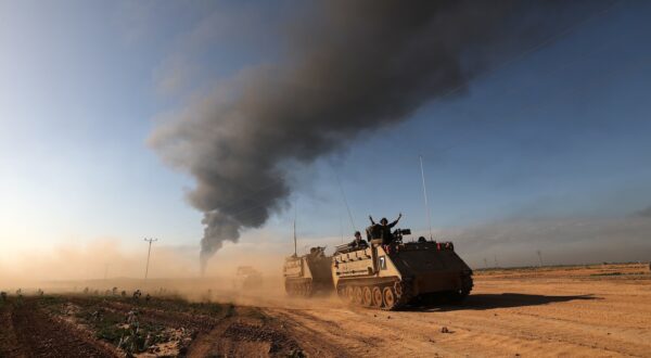 epa11094194 Israeli APCs patrolling along the southern part of the border with the Gaza Strip, as smoke billows from the area near Khan Yunis in the background, 21 January 2024. More than 25,000 Palestinians and at least 1,300 Israelis have been killed, according to the Palestinian Health Ministry and the Israel Defense Forces (IDF), since Hamas militants launched an attack against Israel from the Gaza Strip on 07 October, and the Israeli operations in Gaza and the West Bank which followed it.  EPA/ATEF SAFADI