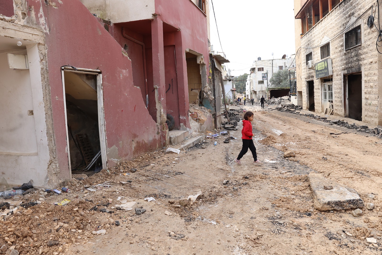 epa11103737 Palestinians walk along a damaged street at the Jenin refugee camp following an overnight Israeli raid in the West Bank city of Jenin, 25 January 2024. More than 25,700 Palestinians and at least 1,330 Israelis have been killed, according to the Palestinian Health Ministry and the Israel Defense Forces (IDF), since Hamas militants launched an attack against Israel from the Gaza Strip on 07 October 2023, and the Israeli operations in Gaza and the West Bank which followed it.  EPA/ALAA BADARNEH