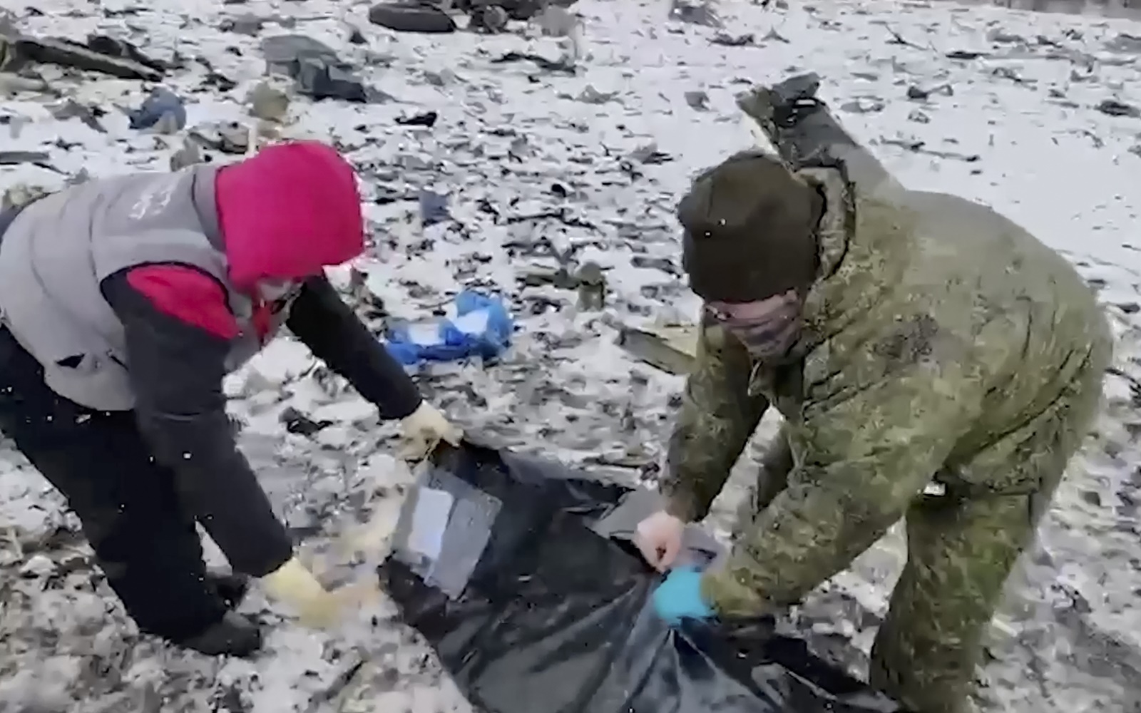 epa11106846 A still image taken from handout video provided by the Russian Investigative Committee on 26 January 2024 shows what investigators say is a body being covered at the crash site of the Russian IL-76 military transport plane near the village of Yablonovo, Belgorod region, Russia. An Ilyushin Il-76 airlifter crashed on 24 January 2024 near the border with Ukraine. The Russian government is accusing Ukraine of shooting down the Il-76 aircraft and is claiming the plane was carrying 65 Ukrainian prisoners of war.  EPA/RUSSIAN INVESTIGATIVE COMMITEE HANDOUT   HANDOUT EDITORIAL USE ONLY/NO SALES HANDOUT EDITORIAL USE ONLY/NO SALES