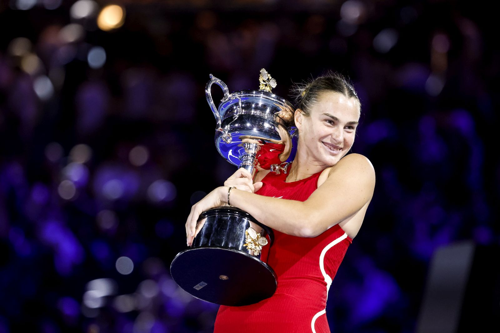 epa11107748 Aryna Sabalenka of Belarus celebrates with the Daphne Akhurst Memorial Cup after winning the Women's final match against Qinwen Zheng of China at the Australian Open tennis tournament in Melbourne, Australia, 27 January 2024.  EPA/MAST IRHAM