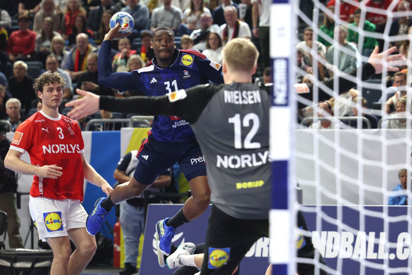 epa11111280 France’s Dylan Nahi (C) in action against Denmark's goalkeeper Emil Nielsen (R) during the EHF Men's EURO 2024 final handball match between France and Denmark in Cologne, Germany, 28 January 2024.  EPA/CHRISTOPHER NEUNDORF