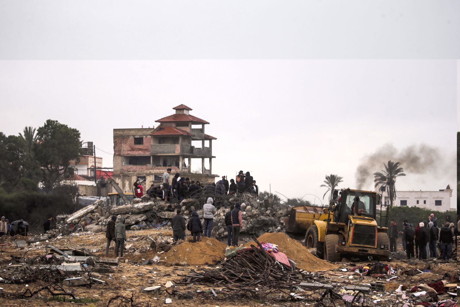 epa11112085 Palestinians search for bodies and survivors among the rubble of a destroyed house following Israeli airstrikes in Deir Al Balah, Gaza Strip, 29 January 2024. More than 26,200 Palestinians and at least 1,330 Israelis have been killed, according to the Palestinian Health Ministry and the Israel Defense Forces (IDF), since Hamas militants launched an attack against Israel from the Gaza Strip on 07 October 2023, and the Israeli operations in Gaza and the West Bank which followed it.  EPA/MOHAMMED SABER
