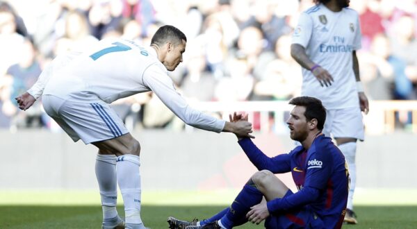 Real Madrid's Cristiano Ronaldo, left, helps Barcelona's Lionel Messi get back on his feet during the Spanish La Liga soccer match between Real Madrid and Barcelona at the Santiago Bernabeu stadium in Madrid, Spain, Saturday, Dec. 23, 2017. (AP Photo/Francisco Seco)