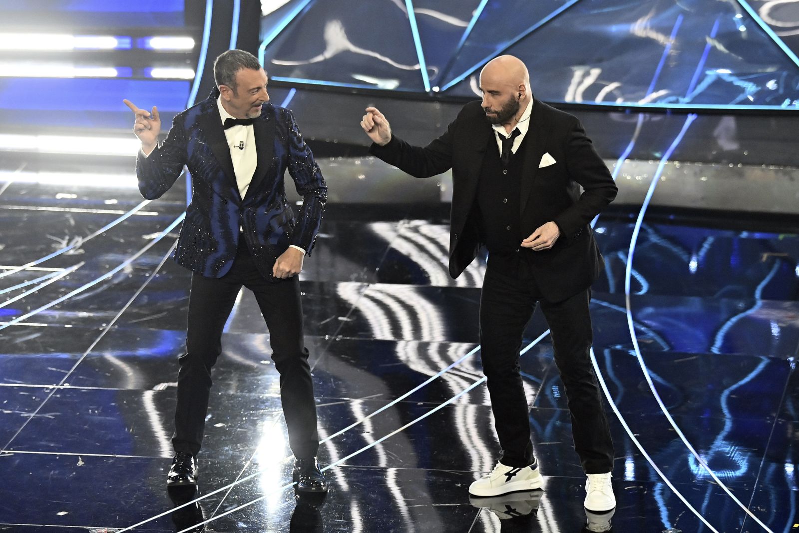 John Travolta, right, and Amadeus perform during the 74th edition of the Sanremo Italian Song Festival at the Ariston Theatre in Sanremo, northern Italy, Tuesday, Feb. 7, 2024. Entertainment. (Marco Alpozzi/LaPresse via AP)