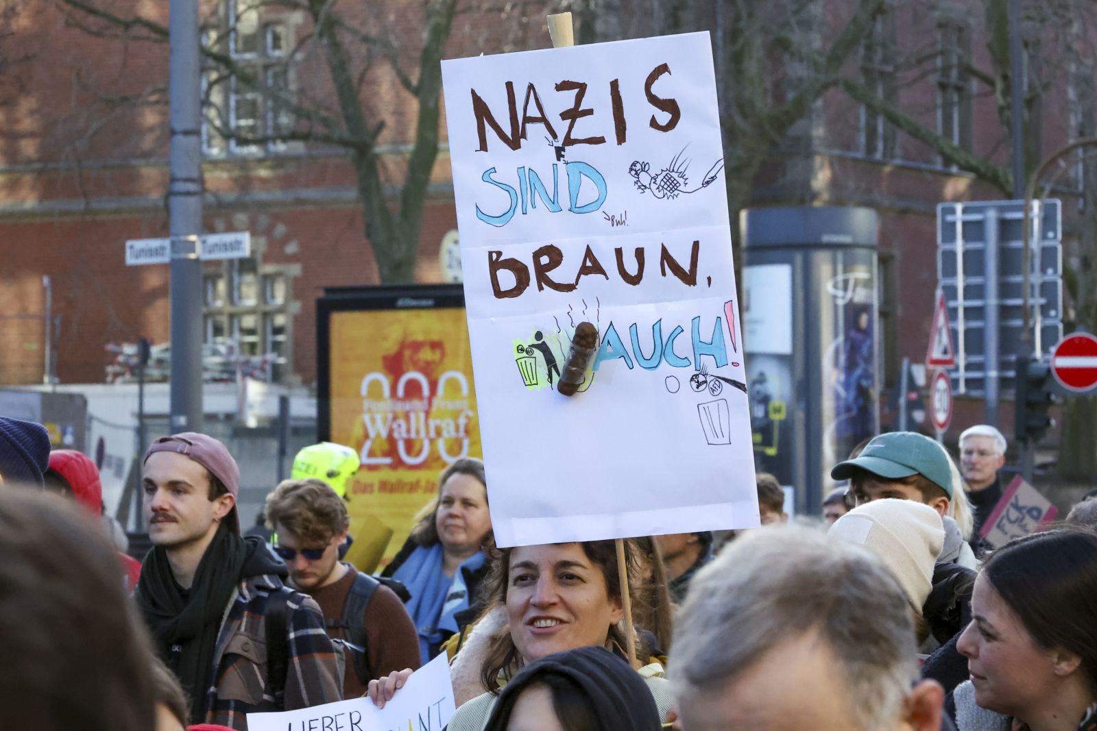 epa11108555 A protester holds a sign reading ‚nazis are brown, poo as well‘ in front of Cologne Cathedral, during a demonstration against the far-right Alternative for Germany (AfD) party in Cologne, Germany, 27 January 2024. According to the alliance 'Together against the right,' rallies are planned in more than 200 cities and municipalities across Germany from 26 to 28 January.  EPA/Christopher Neundorf