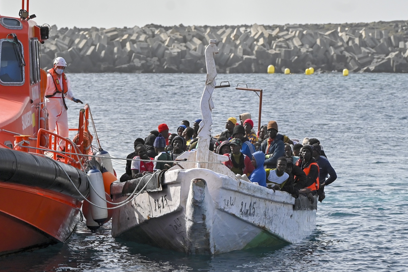 epa11112786 Migrants react upon arrival to La Restinga's port, in El Hiero, Canary islands, Spain, 29 January 2024. 108 migrants were rescued by Spanish 'Salvamento Maritimo' Maritime Safety and Rescue Society as they sailed aboard a dugout nearby. A total of 255 migrants, among which were five children, have been rescued within the last few hours in three different dugouts.  EPA/GELMERT FINOL