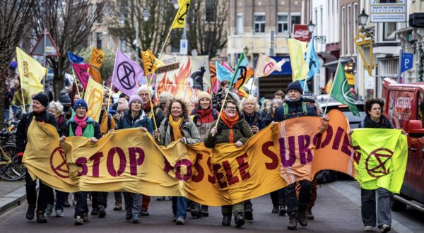 epa11122901 Climate activists from the Extinction Rebellion (XR) carry a banner as they stage a blockade on the Utrechtsebaan, a section of the A12 motorway, to demand an end to fossil fuel subsidies in The Hague, the Netherlands, 03 February 2024.  EPA/RAMON VAN FLYMEN