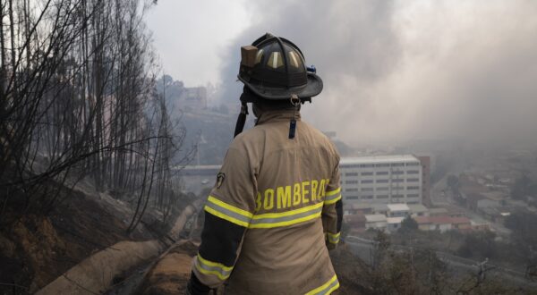 epa11124886 A firefighter observes the forest fires affecting the Beagle Channel area, Vina del Mar, Valparaiso Region, Chile, 03 February 2024. The fires in the central region of Valparaiso have caused at least 19 deaths, according to official reports.  EPA/ADRIANA THOMASA