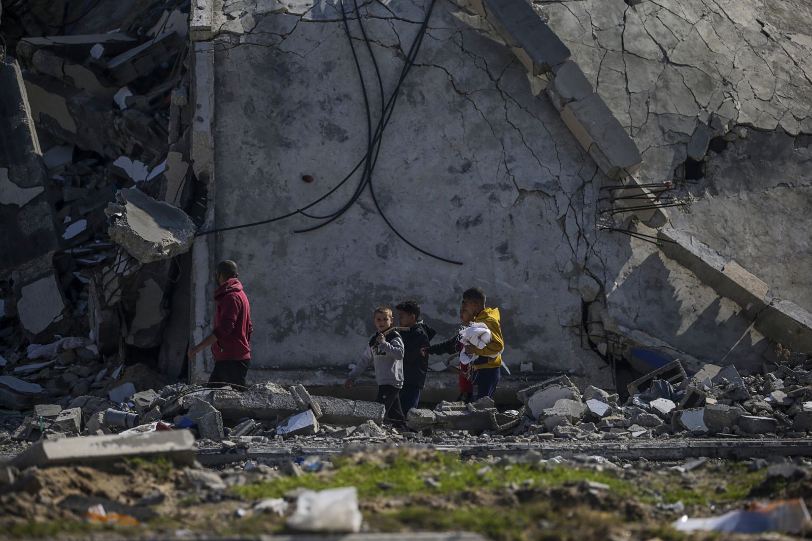 epa11131174 A Palestinian man and his sons inspecting their destroyed house following an Israeli air strike on the Al Maghazi refugee camp, southern Gaza Strip, 06 February 2024. More than 27,000 Palestinians and over 1,300 Israelis have been killed, according to the Palestinian Health Ministry and the Israel Defense Forces (IDF), since Hamas militants launched an attack against Israel from the Gaza Strip on 07 October 2023, and the Israeli operations in Gaza and the West Bank which followed it.  EPA/MOHAMMED SABER
