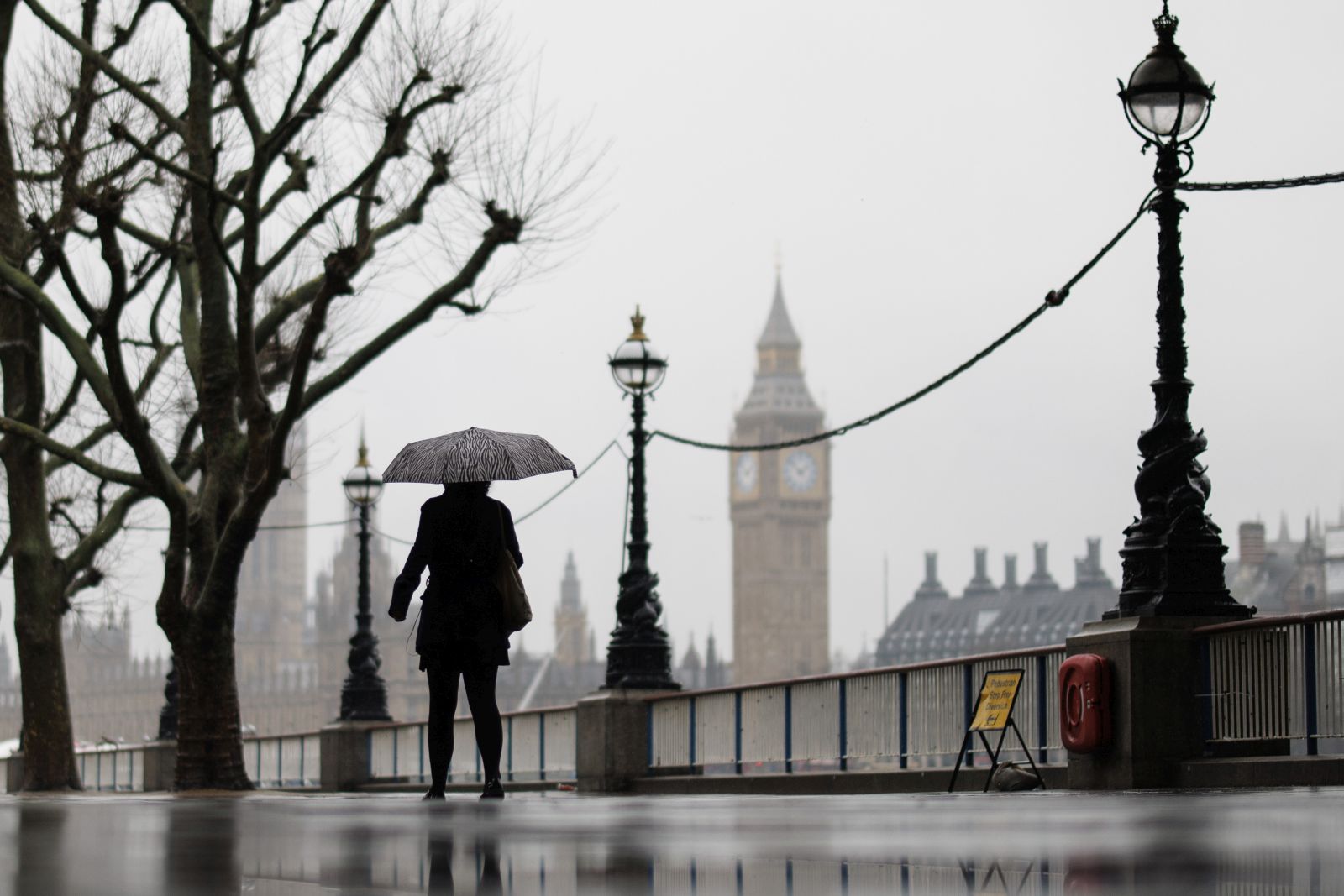 epa11137216 People walk along the Southbank in the rain with The Palace of Westminster, home to the Houses of Parliament, in the background in London, Britain, 08 February 2024. The UK Met Office has issued a yellow warning covering much of southern England as heavy rain is likely to cause disruption to transport.  EPA/TOLGA AKMEN