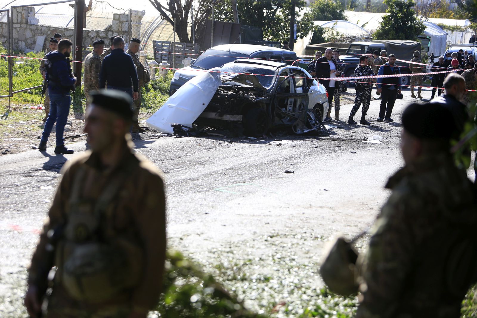 epa11142308 Lebanese army soldiers stand around a  wrecked car following a drone strike in the village of Jadra, between Beirut and Sidon, Lebanon, 10 February 2024. Lebanese state media said at least two people were killed in an Israeli drone strike on a car in the town of Jadra, in the Chouf district. Hamas said a senior member survived the attack, and the Israeli army did not comment on the incident.  EPA/STR