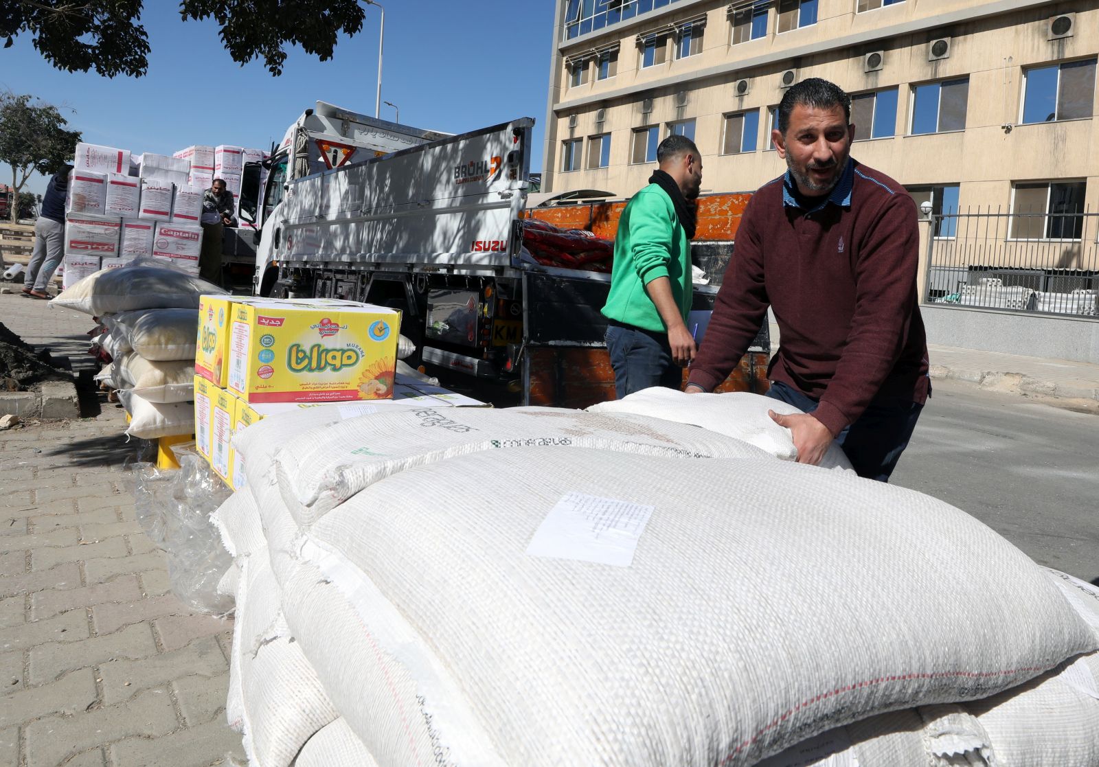 epa11144641 Workers load sacks with food as the non-governmental organization Egyptian Food Bank prepares food donations for Palestinians in the Gaza Strip, at a warehouse in New Cairo, Egypt, 11 February 2024. The Egyptian Food Bank gathers urgent food aid with basic food items for families in need in the Gaza Strip. The aid will be sent to Rafah border crossing. Since 07 October 2023, up to 1.9 million people, or more than 85 percent of the population, have been displaced throughout the Gaza Strip, some more than once, according to the United Nations Relief and Works Agency for Palestine Refugees in the Near East (UNRWA), which added that most civilians in Gaza are in 'desperate need of humanitarian assistance and protection'.  EPA/KHALED ELFIQI