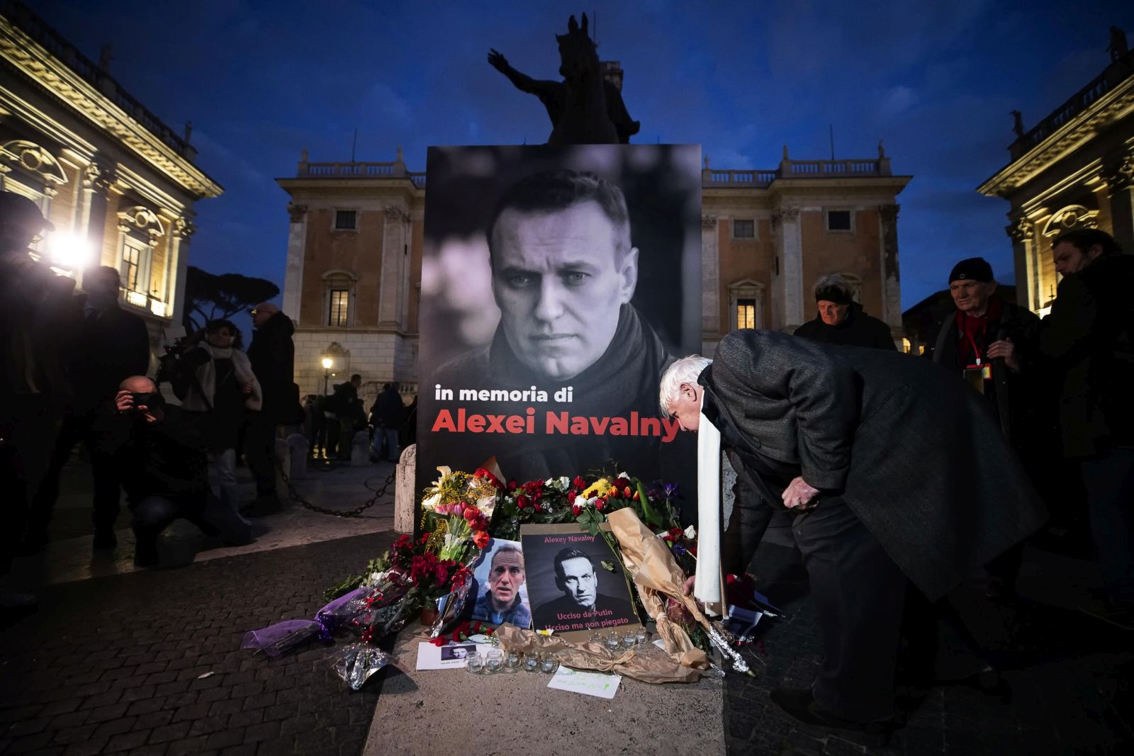 epa11167032 People pay their respects as they attend a torchlight procession in memory of Russian opposition leader Alexei Navalny, who died on 16 February in a Arctic penal colony, the Federal Penitentiary Service of the Yamalo-Nenets Autonomous District, in Capitol Square, Rome, Italy, 19 February 2024.  EPA/ANGELO CARCONI
